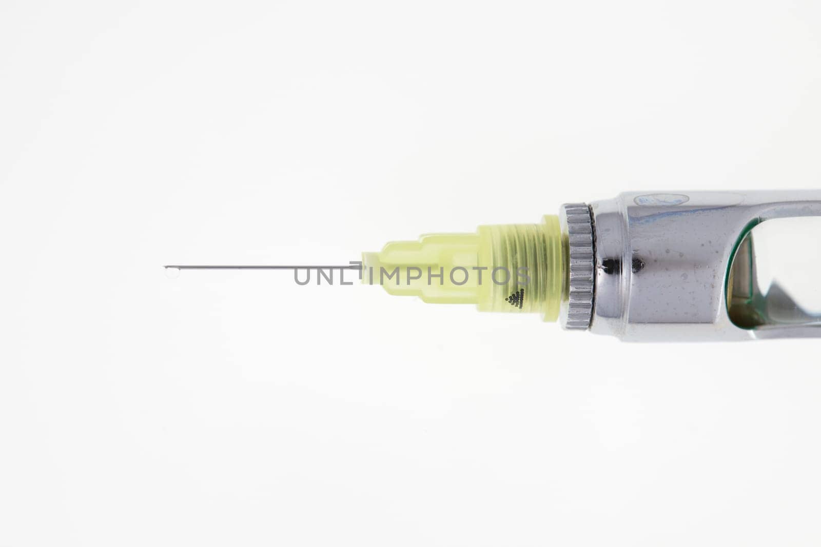 Steel dental syringe for local anesthesia, isolated on white. Carpool syringe for anesthesia in dentistry. Thin needle on a syringe for anesthesia in dentistry.