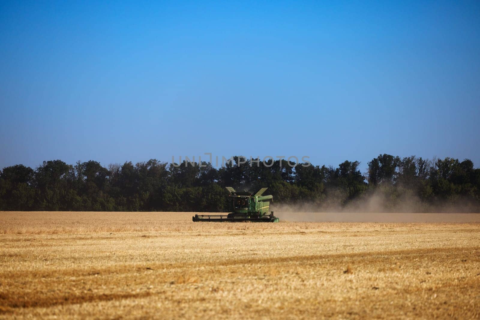 John Deere harvester works in the field. Combine Harvesting Wheat. Field field of cereals during harvesting. Modern equipment works. 07.07.22, Rostov region, Russia.