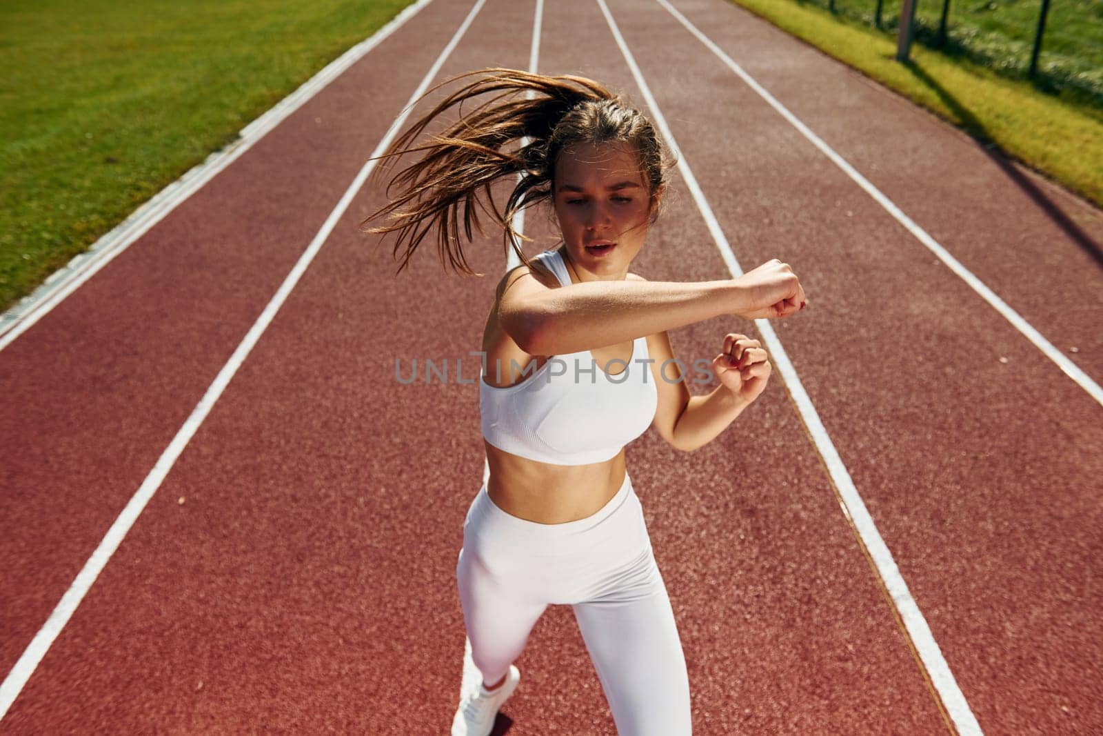 Practicing fight techniques. Young woman in sportive clothes is exercising outdoors.