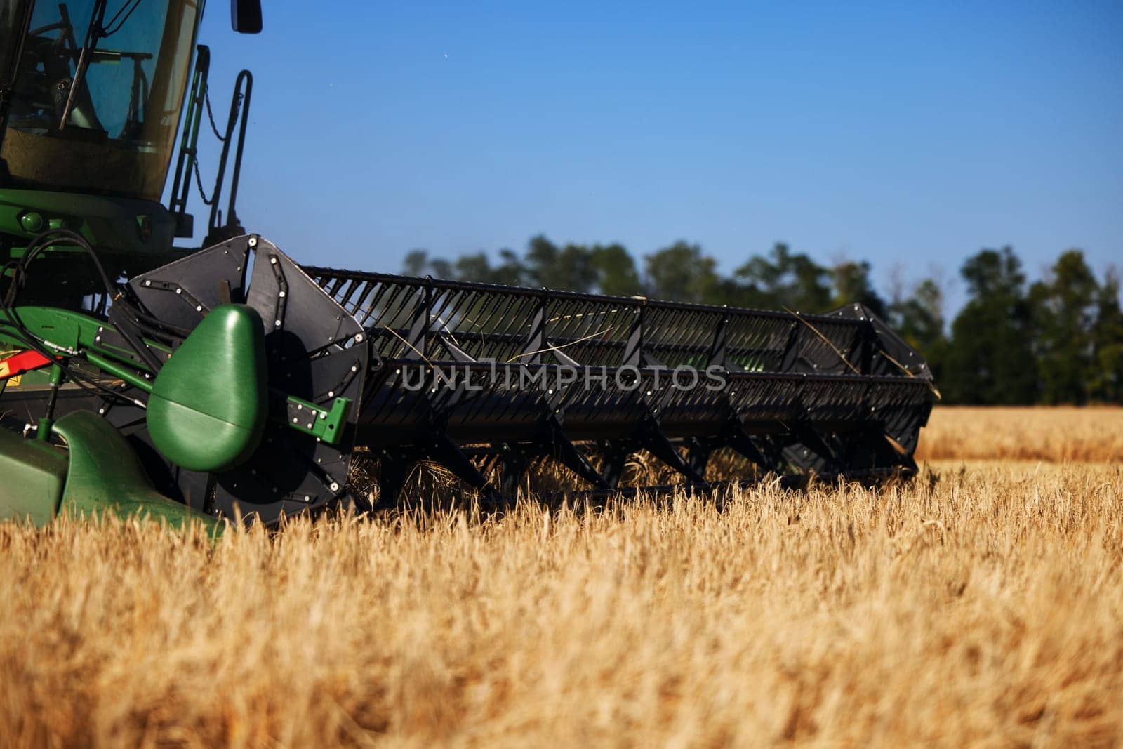 John Deere harvester works in the field. Combine Harvesting Wheat. Field field of cereals during harvesting. Modern equipment works. 07.07.22, Rostov region, Russia.