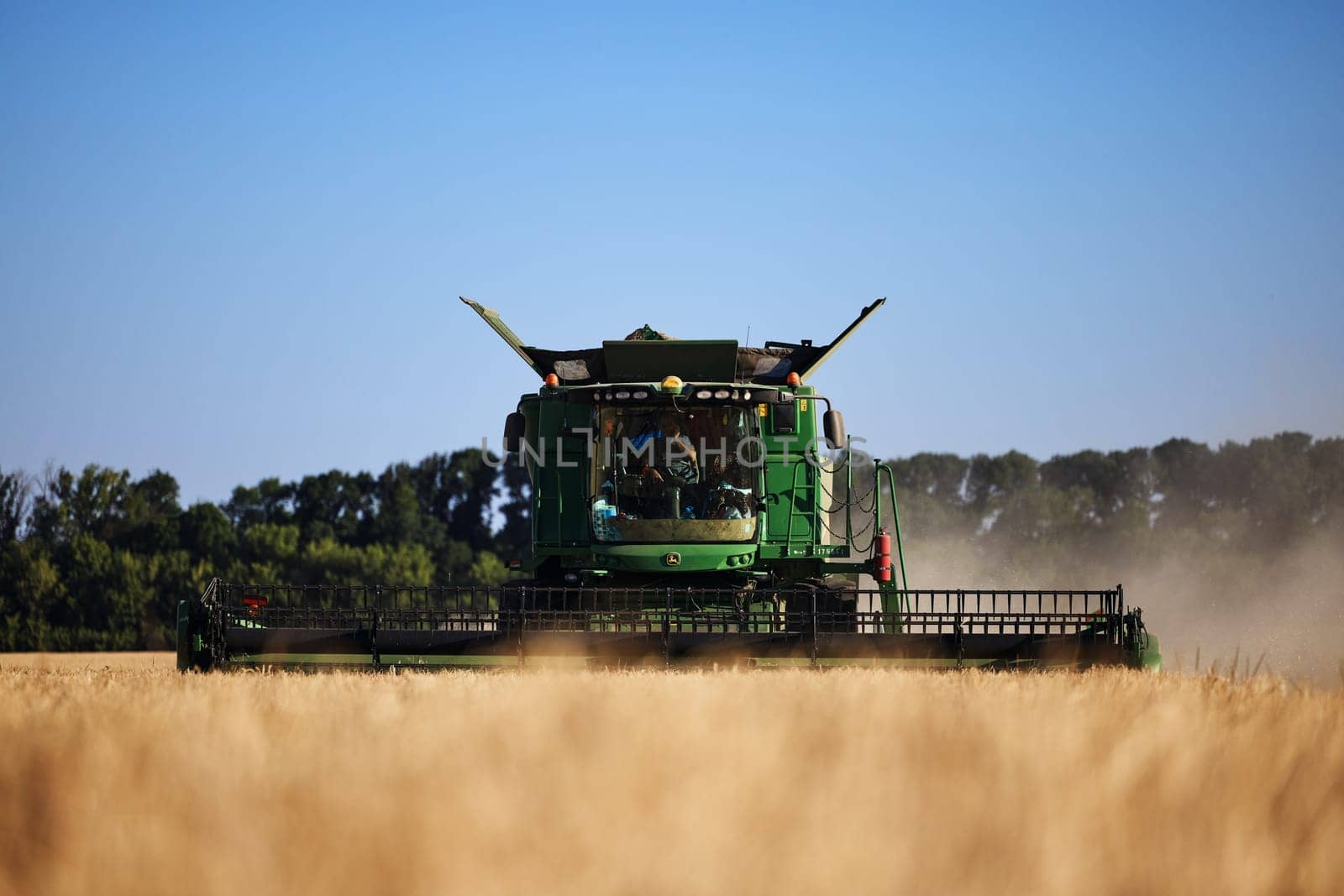 John Deere harvester works in the field. Combine Harvesting Wheat. Field field of cereals during harvesting. Modern equipment works. 07.07.22, Rostov region, Russia.
