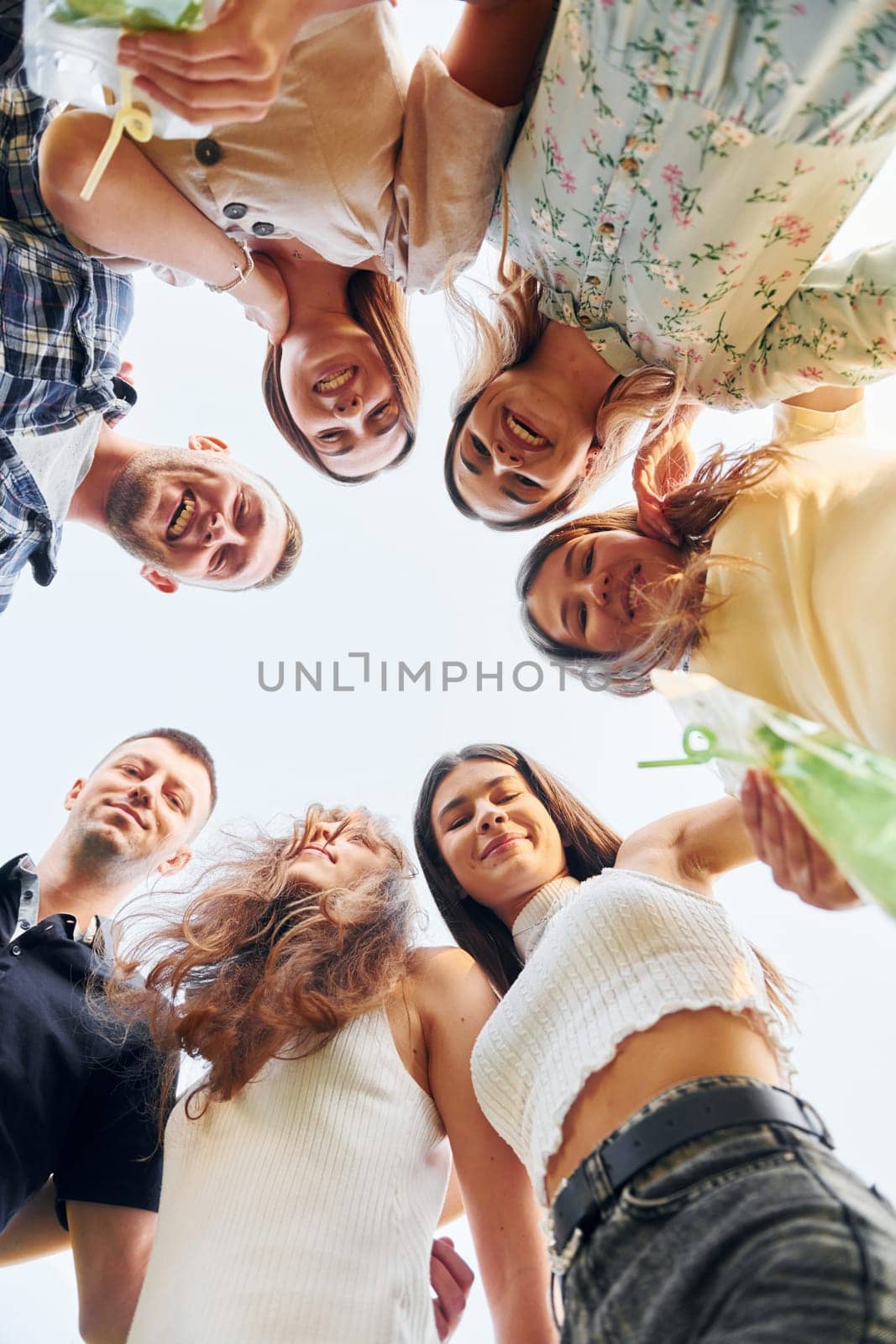 View from below of young positive people that looking down.