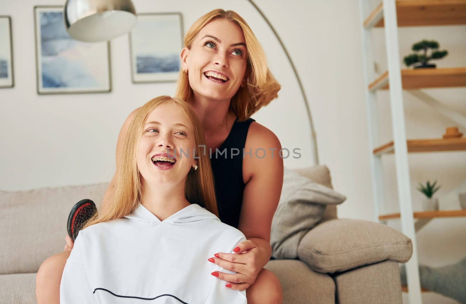 Positive emotions. Female teenager with her mother is at home at daytime.