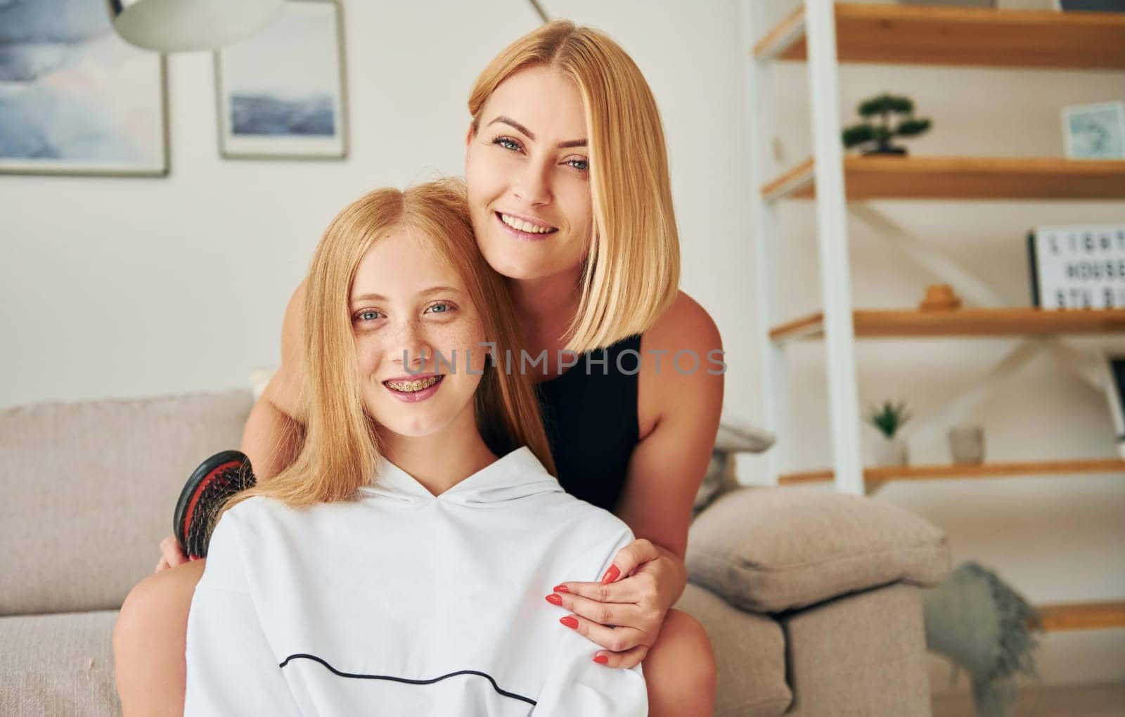 Positive emotions. Female teenager with her mother is at home at daytime by Standret