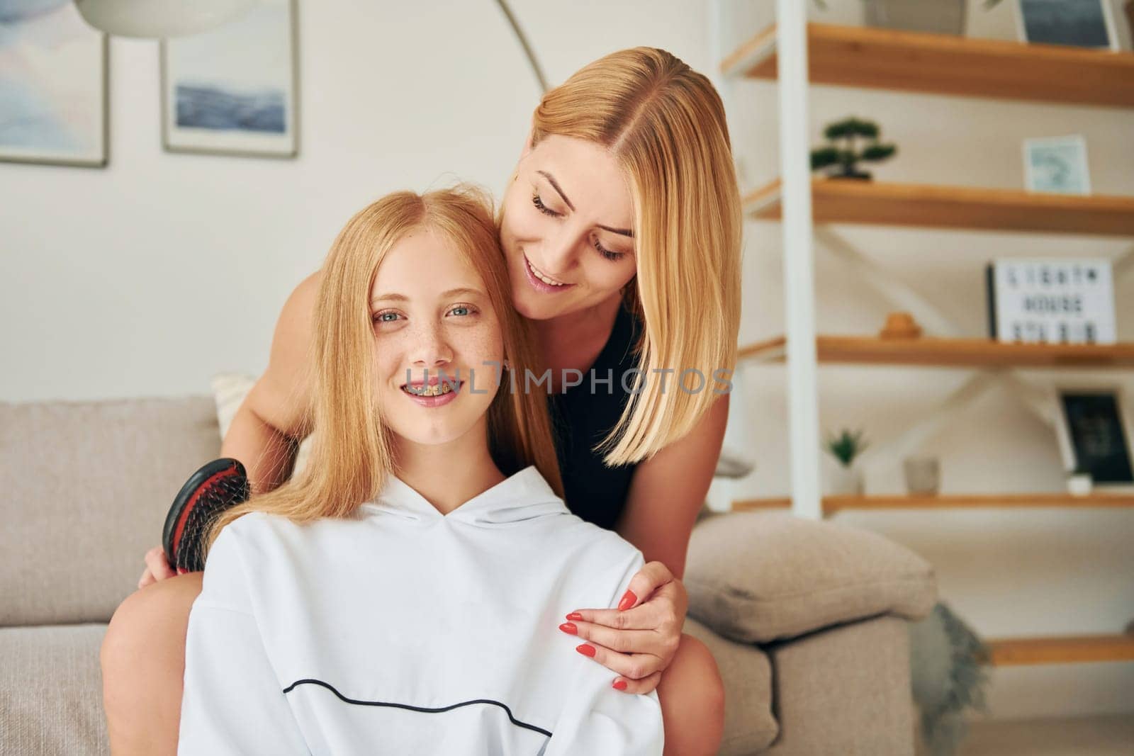 Positive emotions. Female teenager with her mother is at home at daytime.