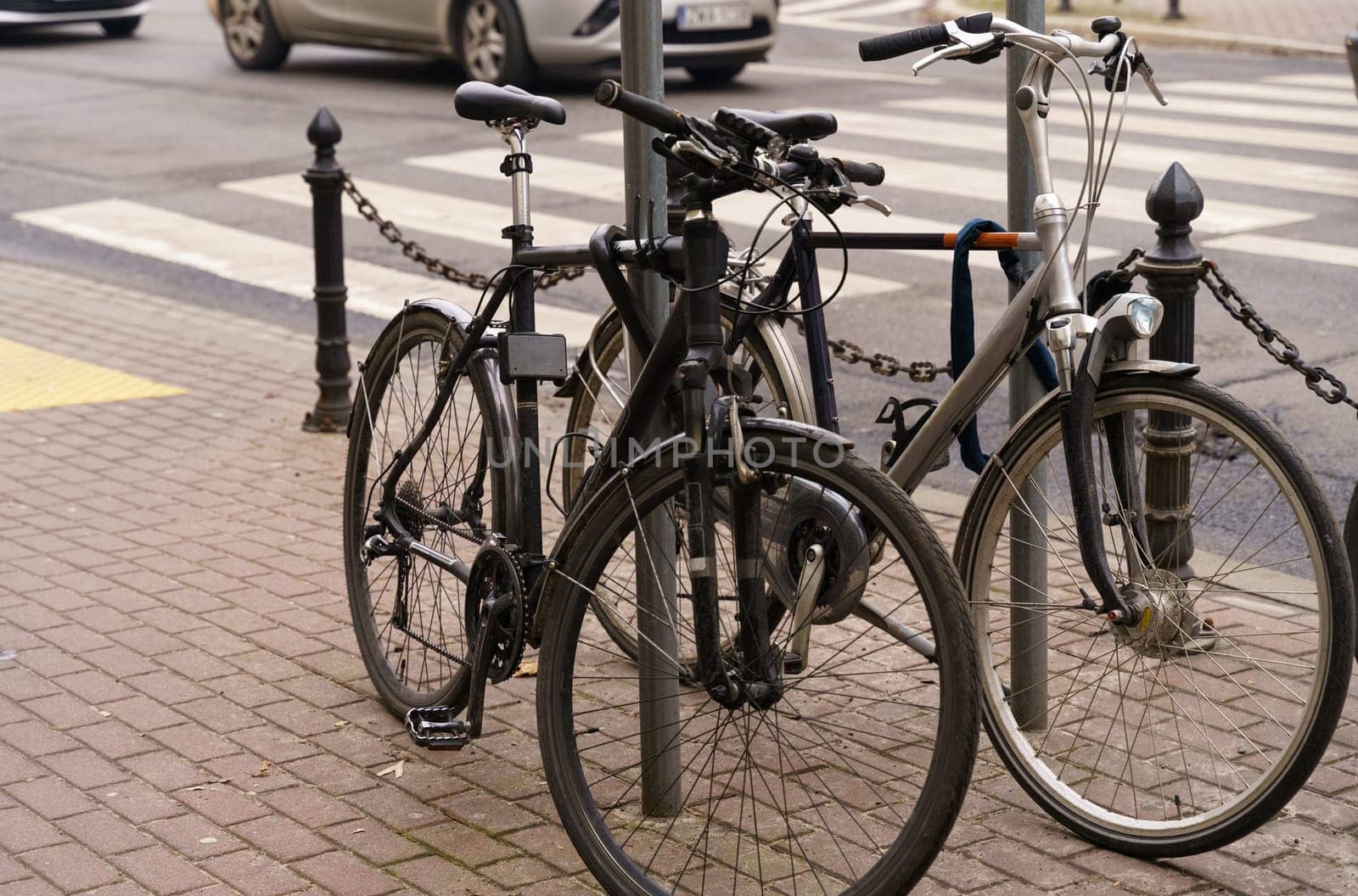 Bicycle parking. Bicycles stand next to each other, in the background are roads and cars.