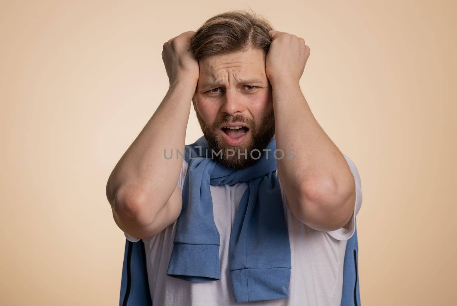 Bearded caucasian man feeling hopelessness loneliness, nervous breakdown, loses becoming surprised by lottery results, bad fortune loss, unlucky news. Young guy isolated on studio beige background