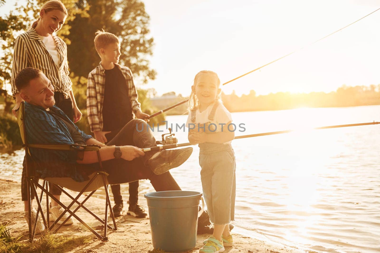 Beautiful nature. Father and mother with son and daughter on fishing together outdoors at summertime.