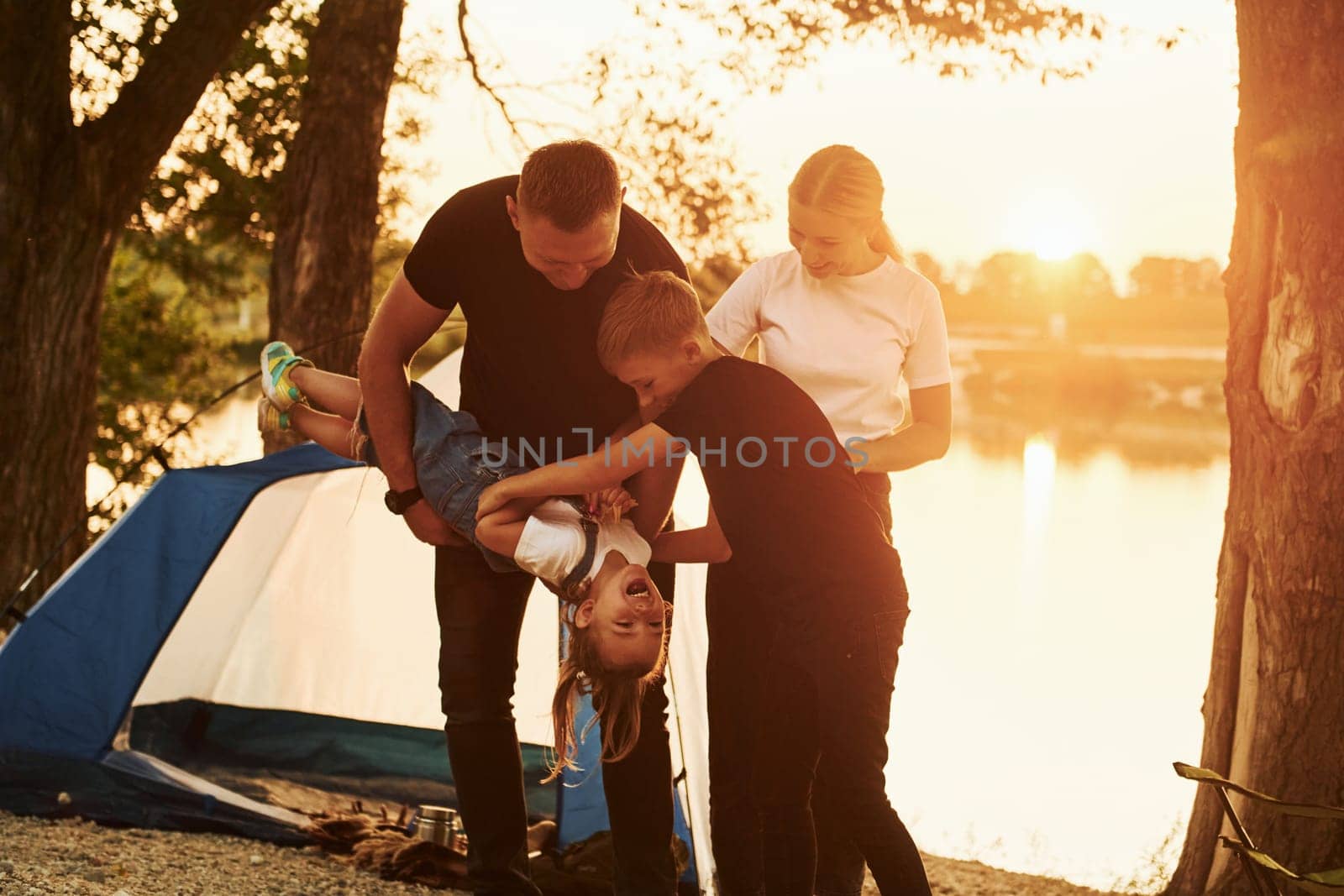 Conception of vacation. Family of mother, father and kids is on the camping.