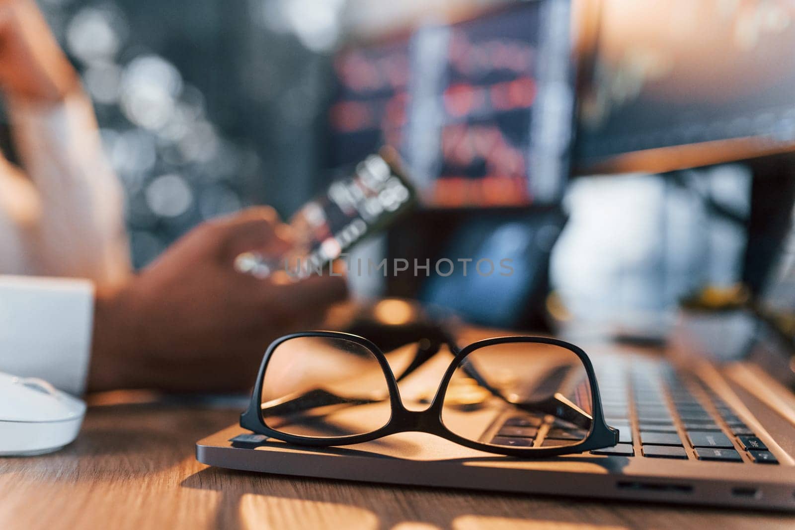 International business. Young man in formal clothes is in office with multiple screens.