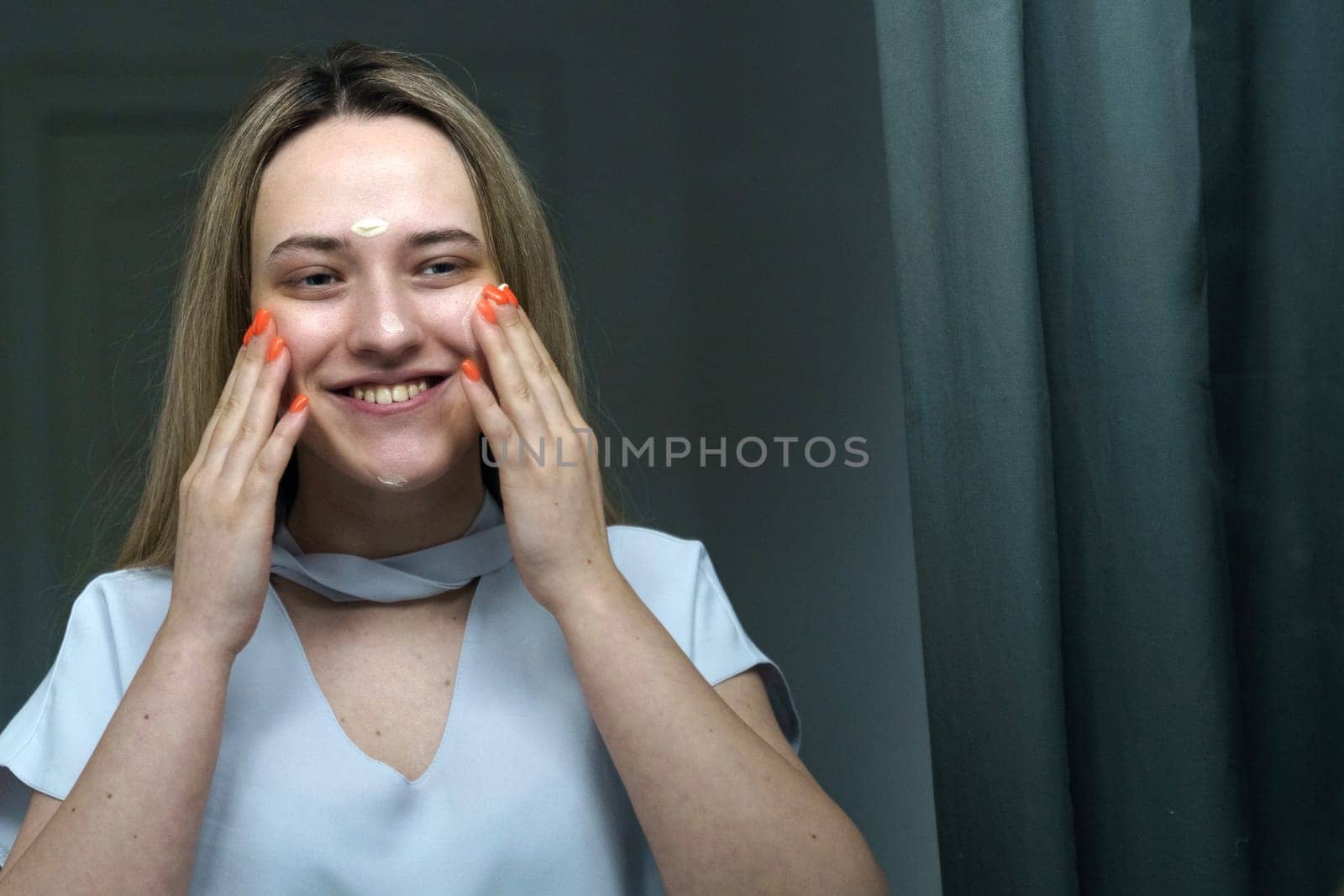A young happy woman takes care of her face in the morning. by Sd28DimoN_1976
