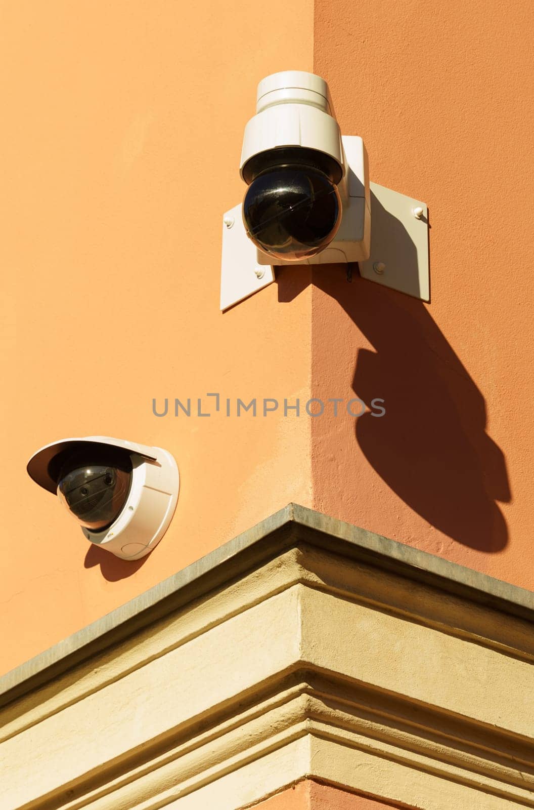 Surveillance cameras are installed on the orange wall of the building. by Sd28DimoN_1976