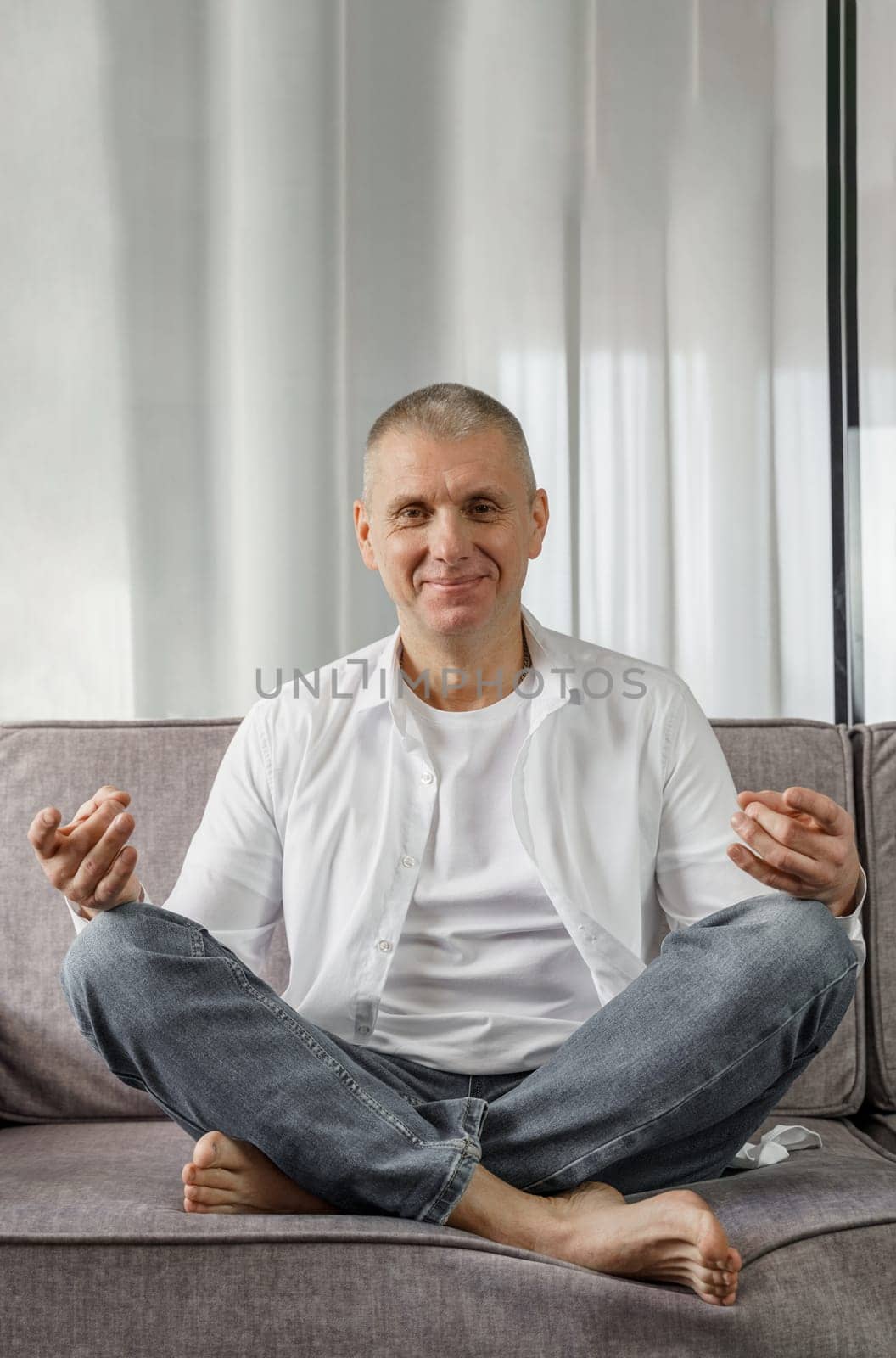 Portrait of a man who sits on a sofa in a room in a lotus position. by Sd28DimoN_1976