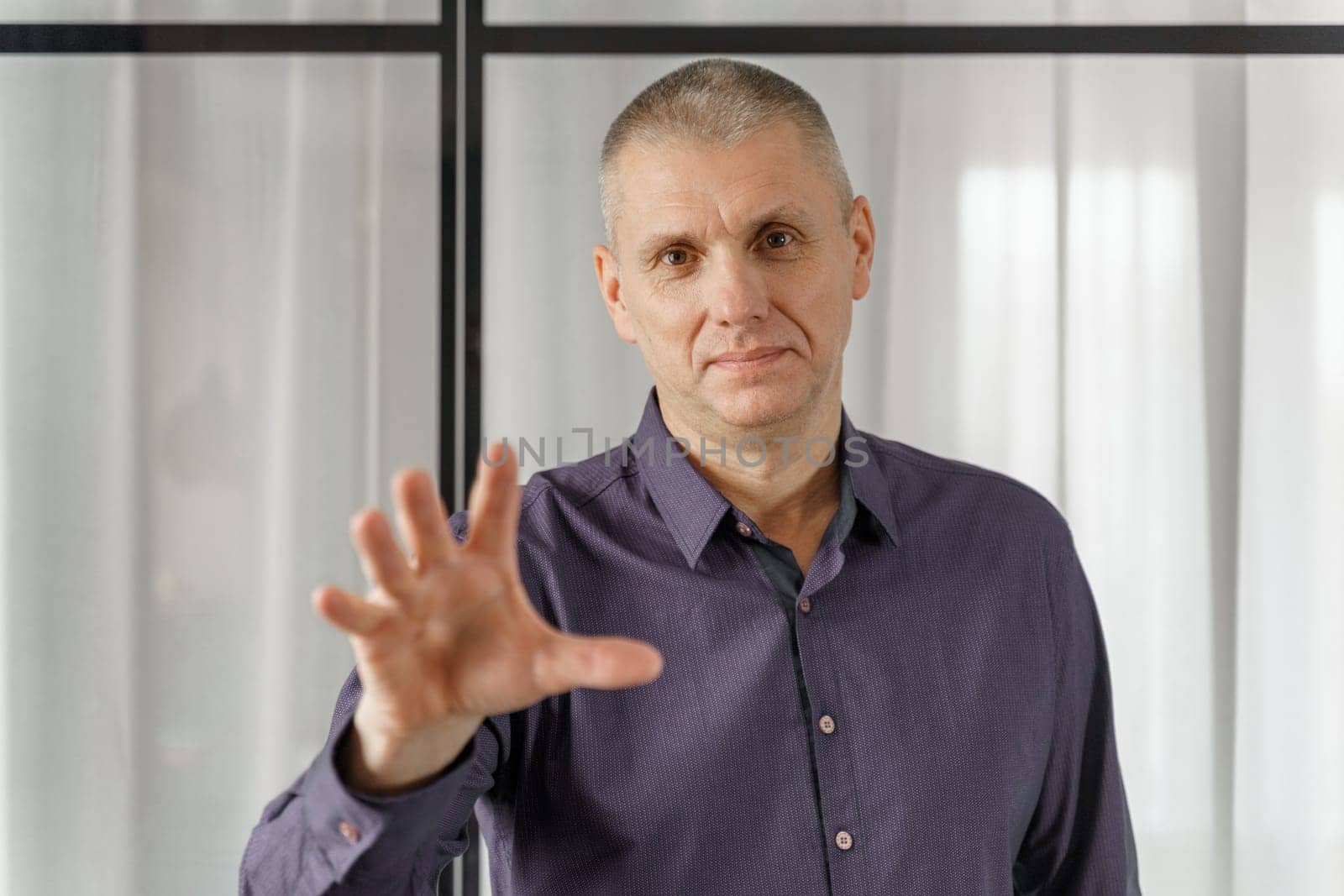 Portrait of a psychosomatic psychologist making a hand gesture to attract attention.