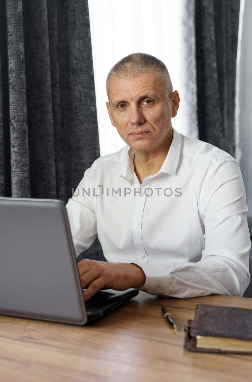 Portrait of middle aged business man working at home with laptop. by Sd28DimoN_1976