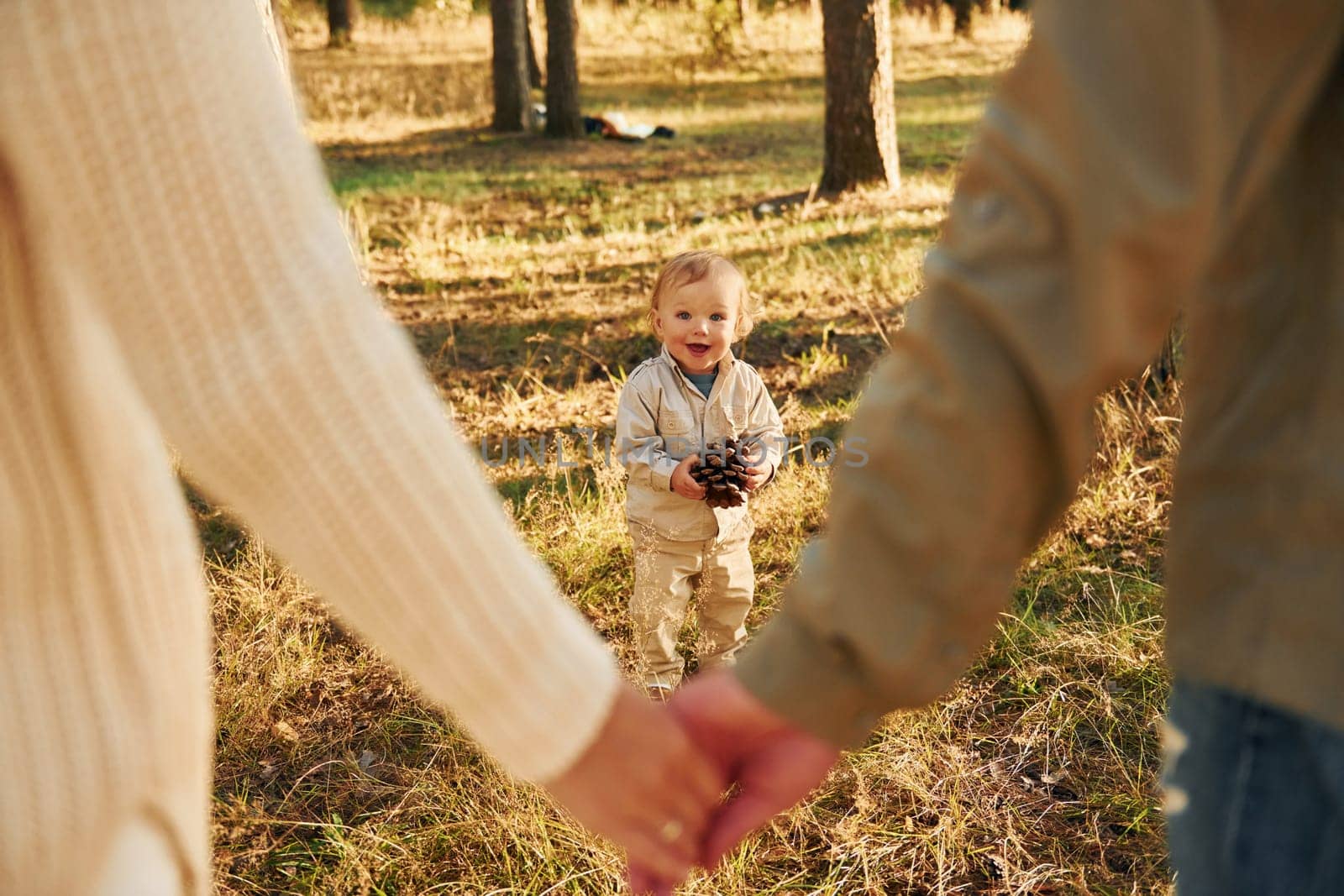 Young people. Happy family of father, mother and little daughter is in the forest.