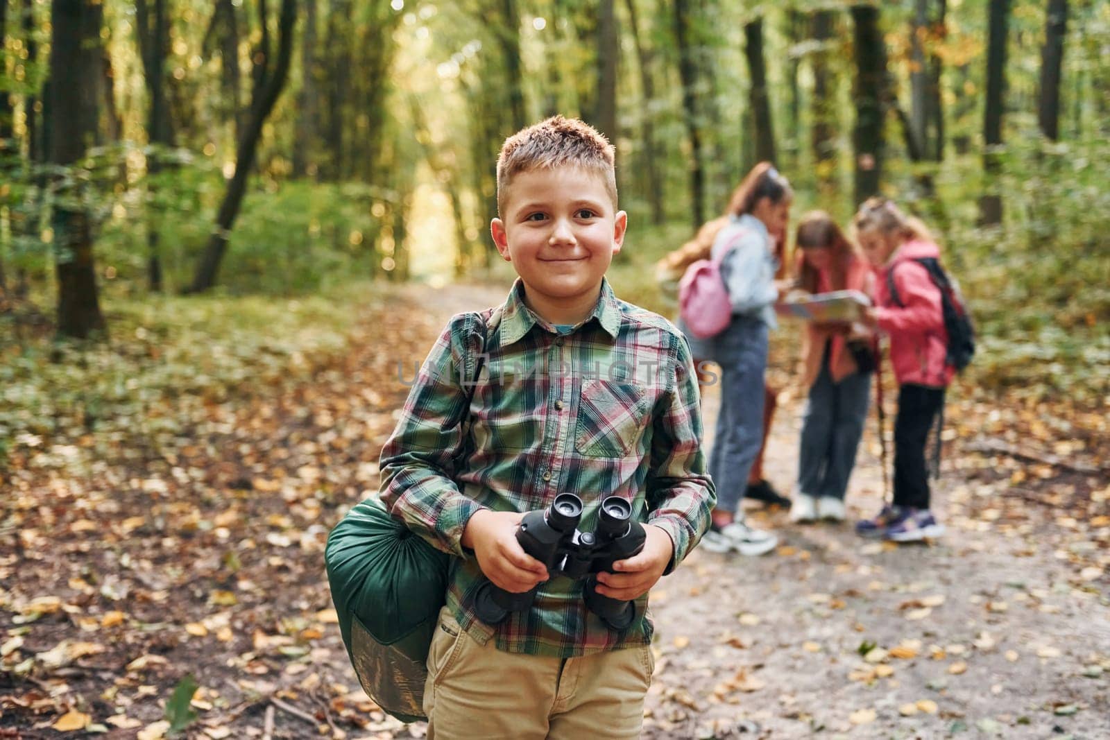 Conception of hiking. Kids in green forest at summer daytime together.