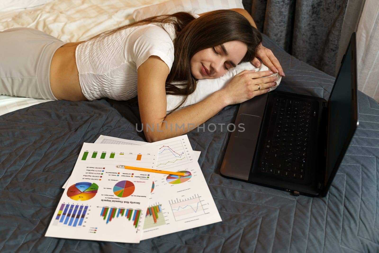 A young girl fell asleep in bed studying reporting information - work. by Sd28DimoN_1976