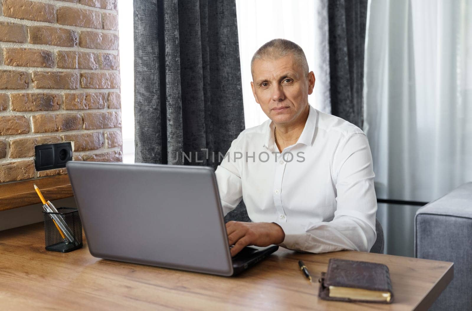 Portrait of middle aged business man working at home with laptop. by Sd28DimoN_1976