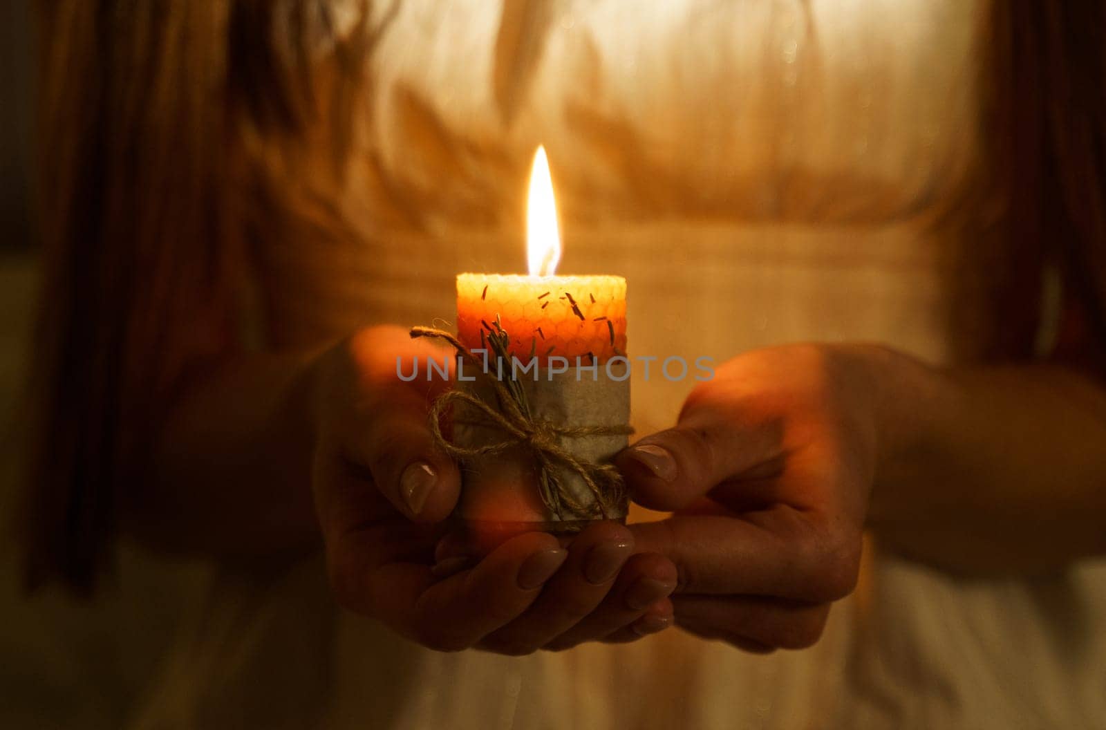 A woman holds a burning candle in her palms on a dark black background. by Sd28DimoN_1976
