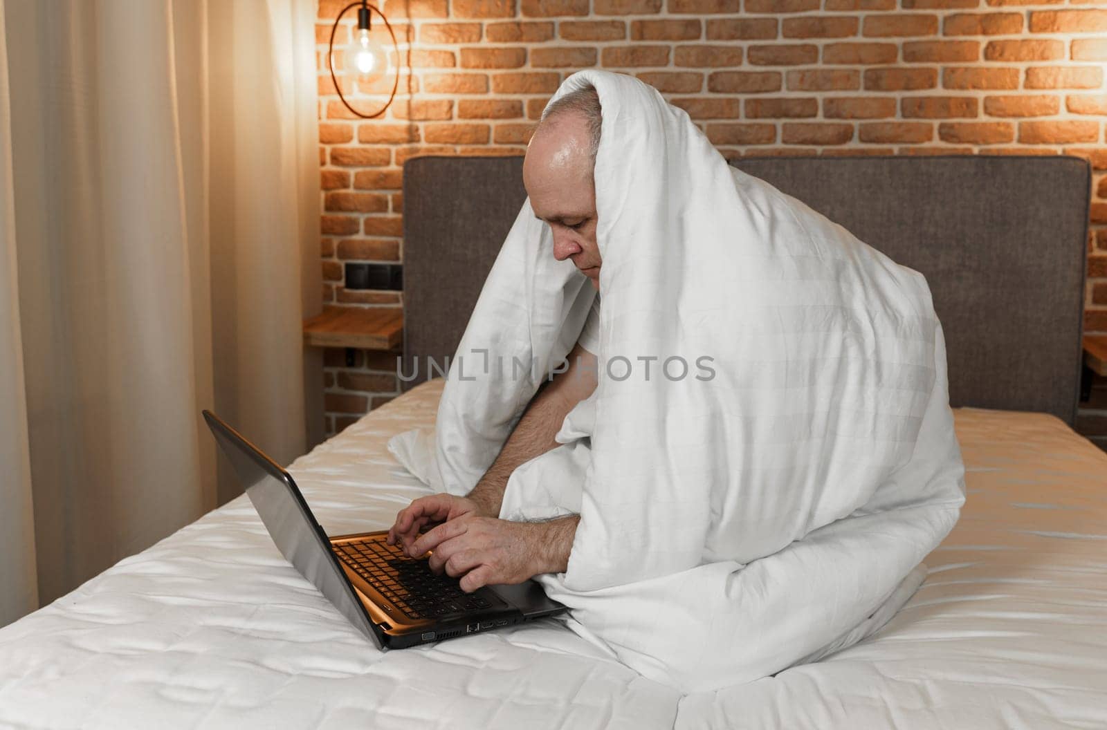 A man is sitting on a bed covered with a blanket, working at a computer by Sd28DimoN_1976