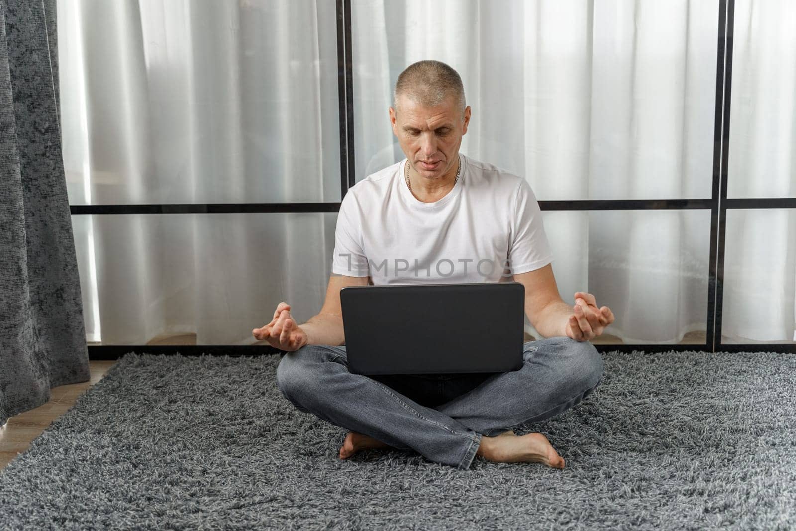 A middle-aged man conducts remote training in yoga, psychosomatics. Vacation and health concept.