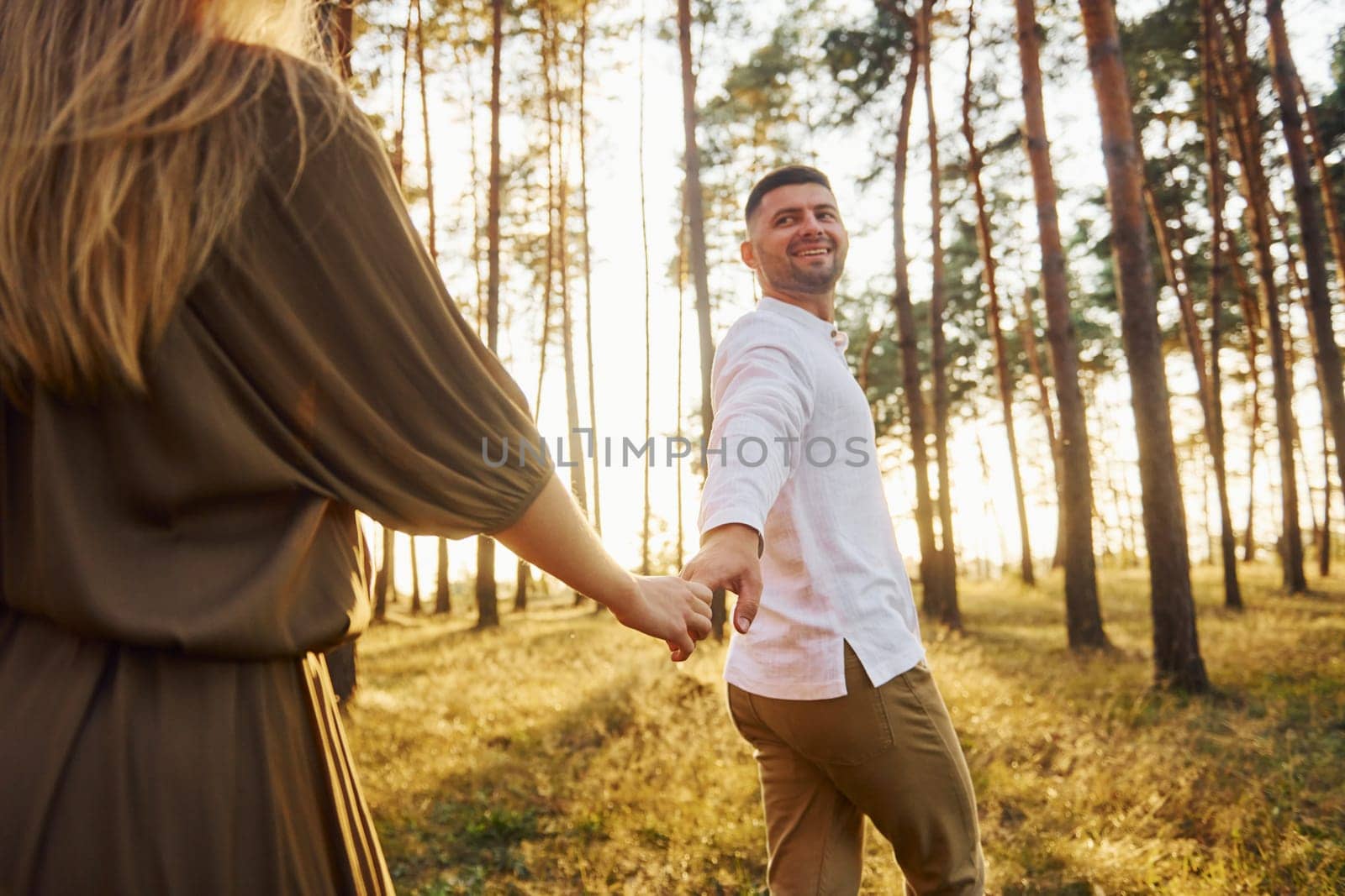 Having a walk. Happy couple is outdoors in the forest at daytime.