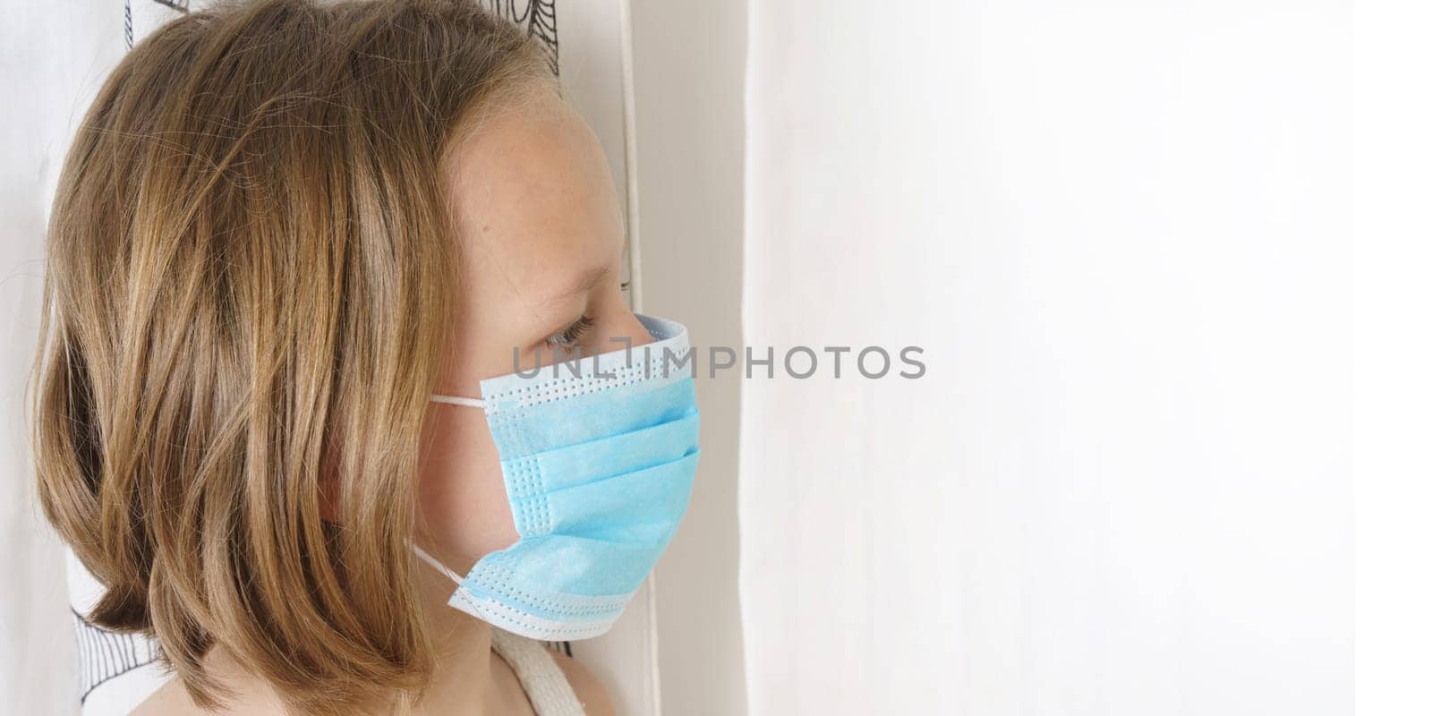 Sick teenage girl in a protective mask looks away. Medical concept.