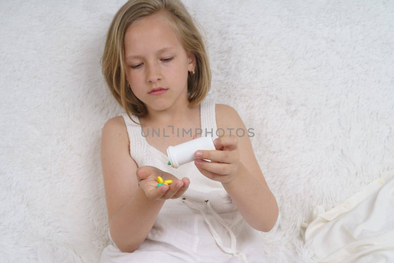 Sick teenage girl spills pills on her hand. Medical concept.