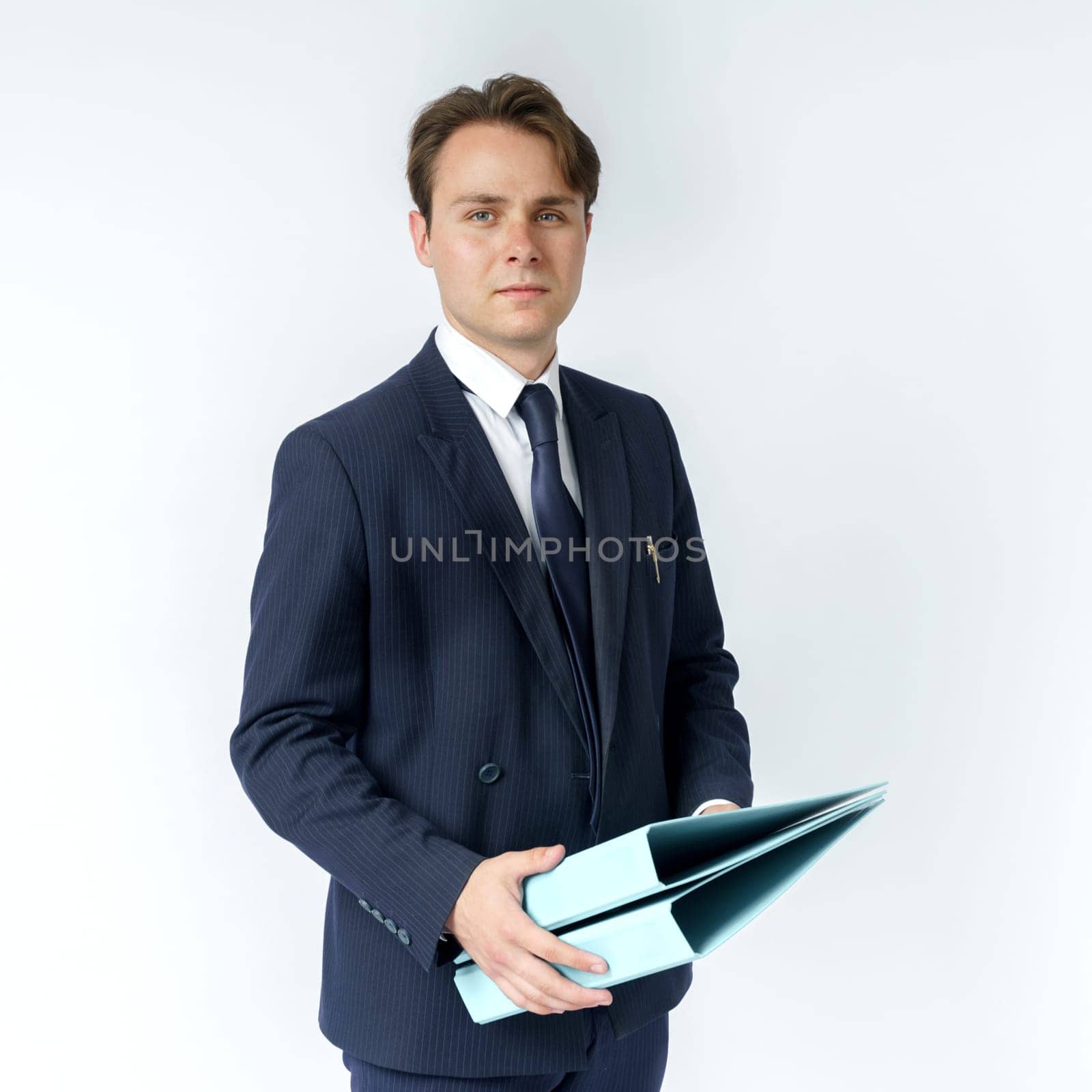 A businessman in a blue suit holds folders on a white background. Business and finance concept