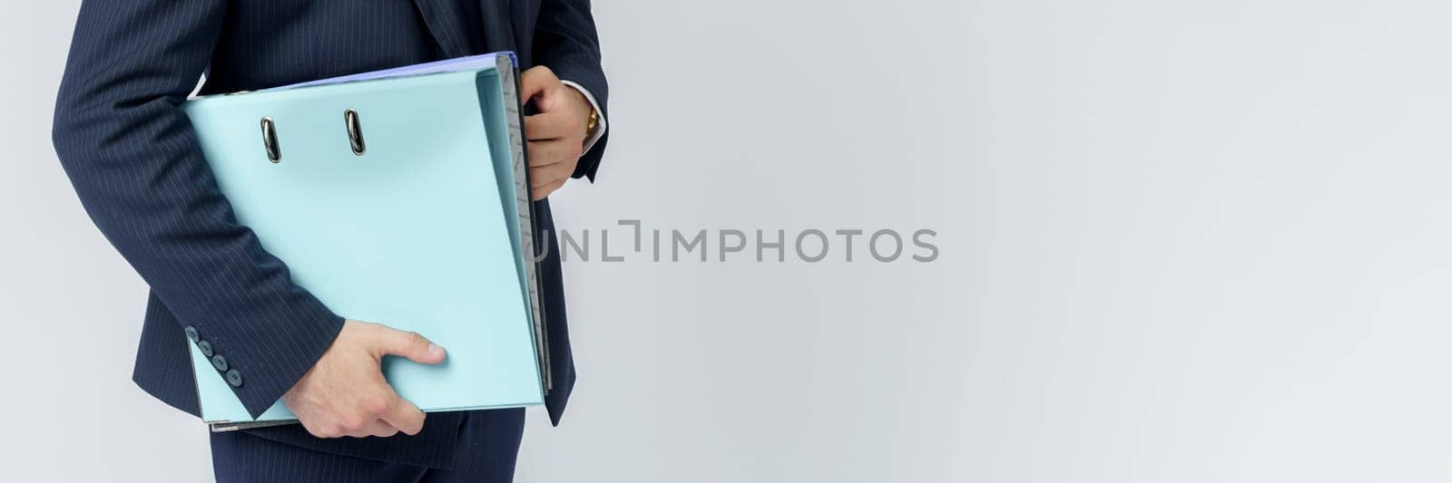 Businessman in a blue suit holds a folder in his hands on a white background. No face visible. Business and finance concept by Sd28DimoN_1976
