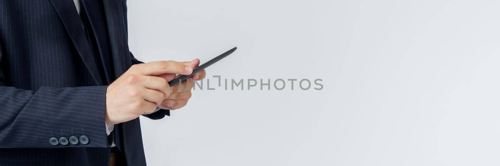 Portrait of a businessman in a blue suit holding an electronic tablet on a white background. Business and finance concept