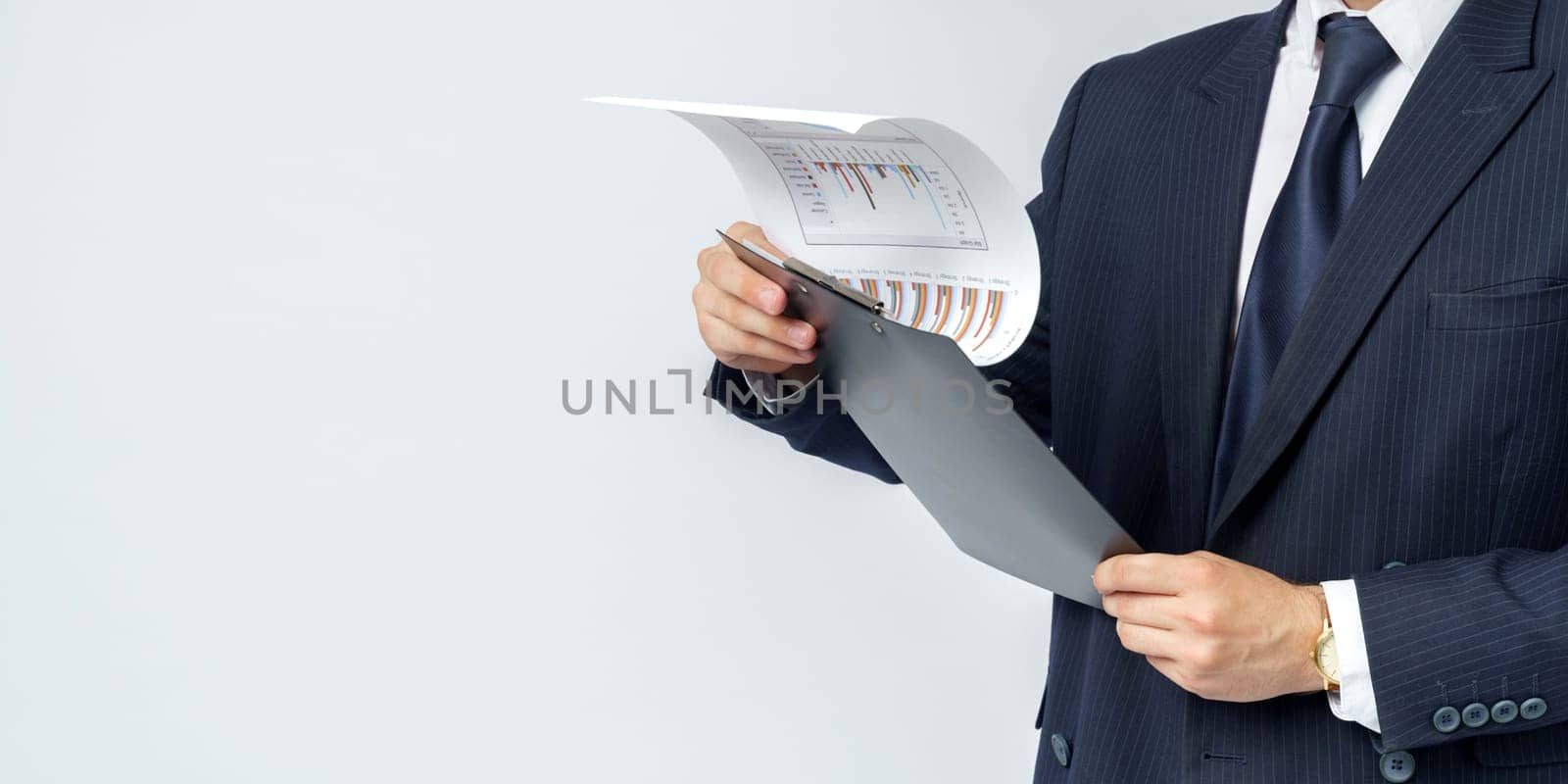 Businessman holds in his hands a tablet with reports. White background. No face visible. Business and finance concept