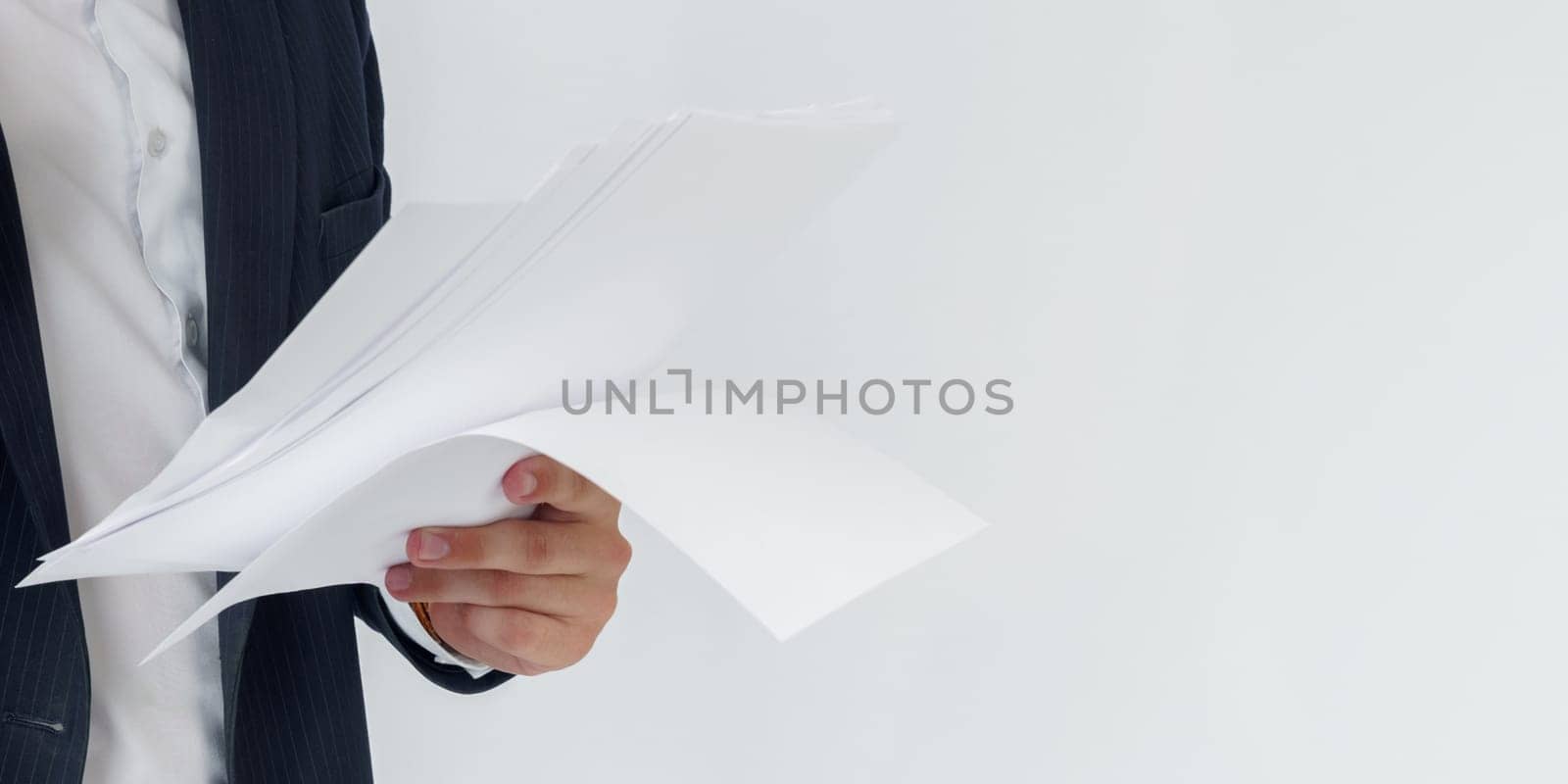 Portrait of a businessman who is talking on the phone and reading documents. No face visible. White background. Business and finance concept
