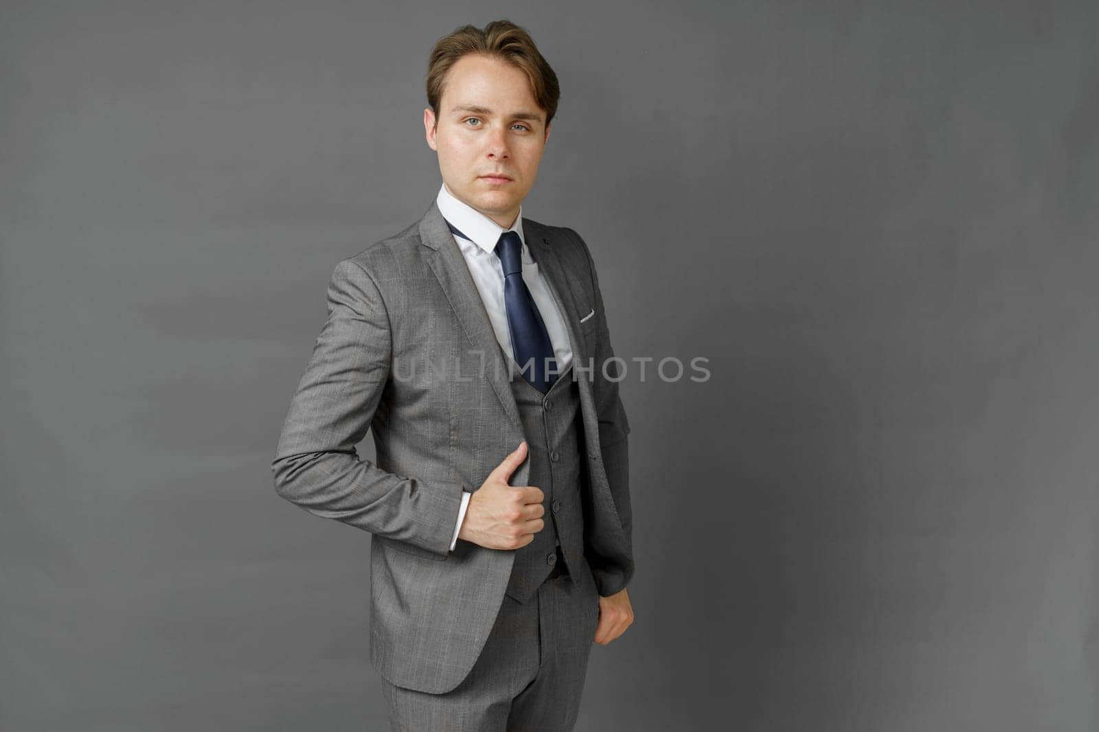 Portrait of a businessman in a suit looking at the camera. Gray background. Business and finance concept