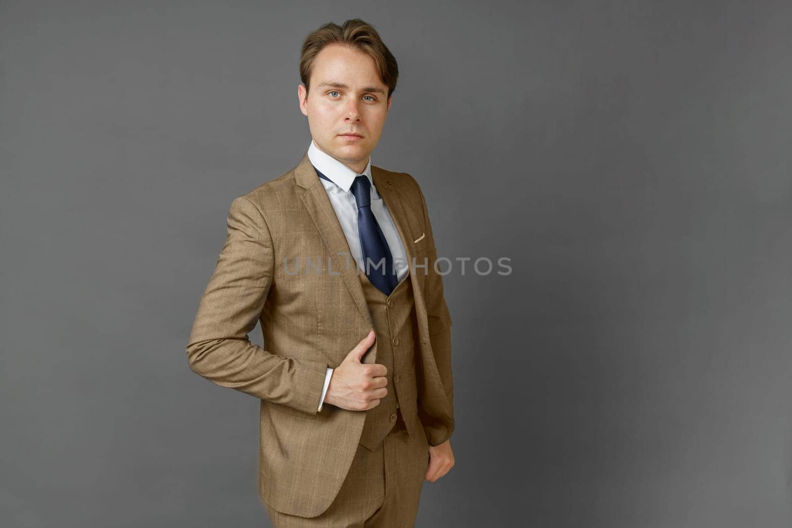 Portrait of a businessman in a suit looking at the camera. Gray background. Business and finance concept