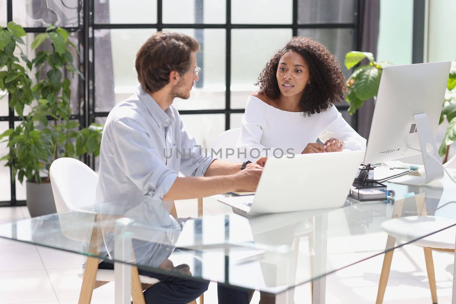 Software developers team discussing algorithms on computer screen.