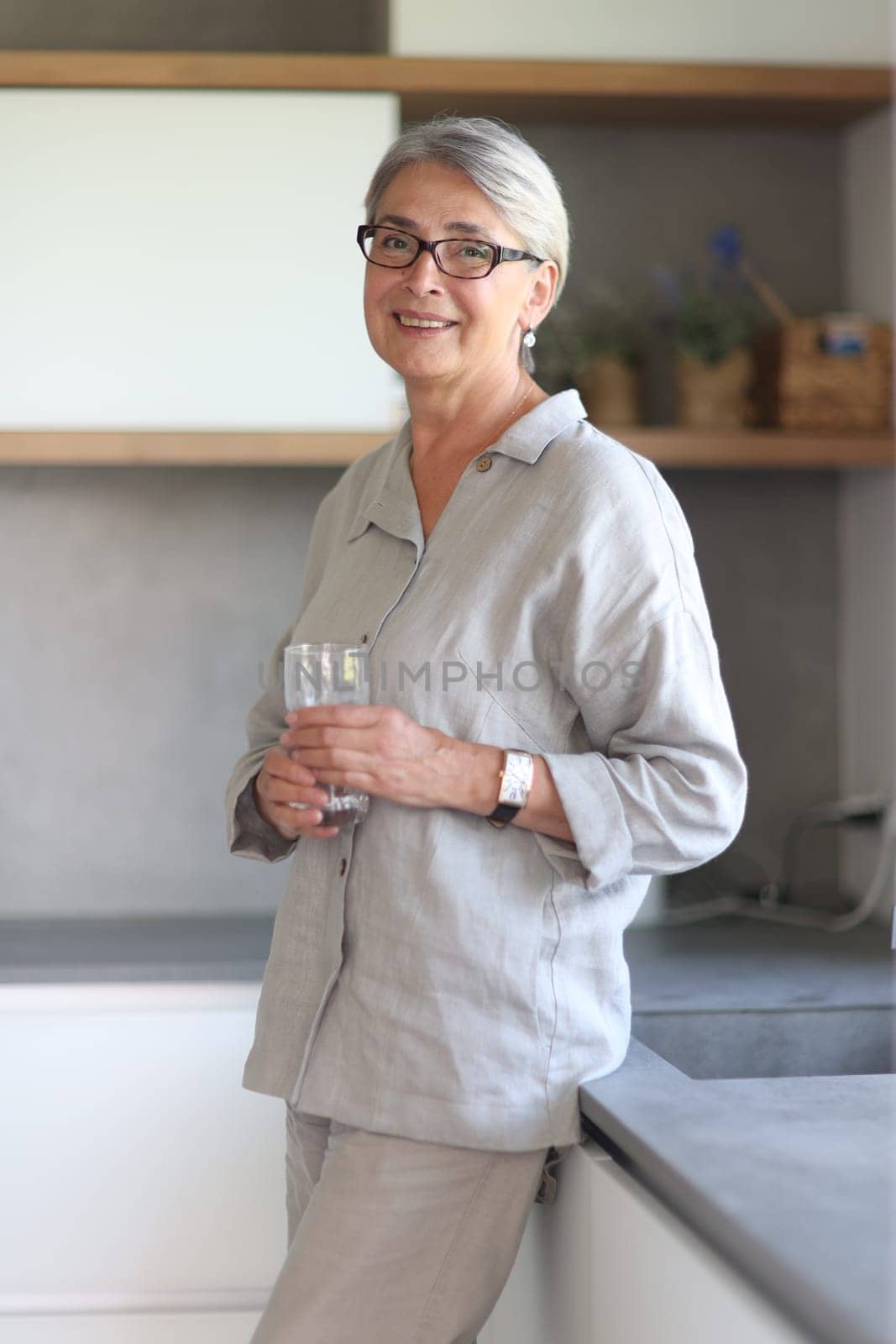 mature woman smiling close up in the office holding a glass of water