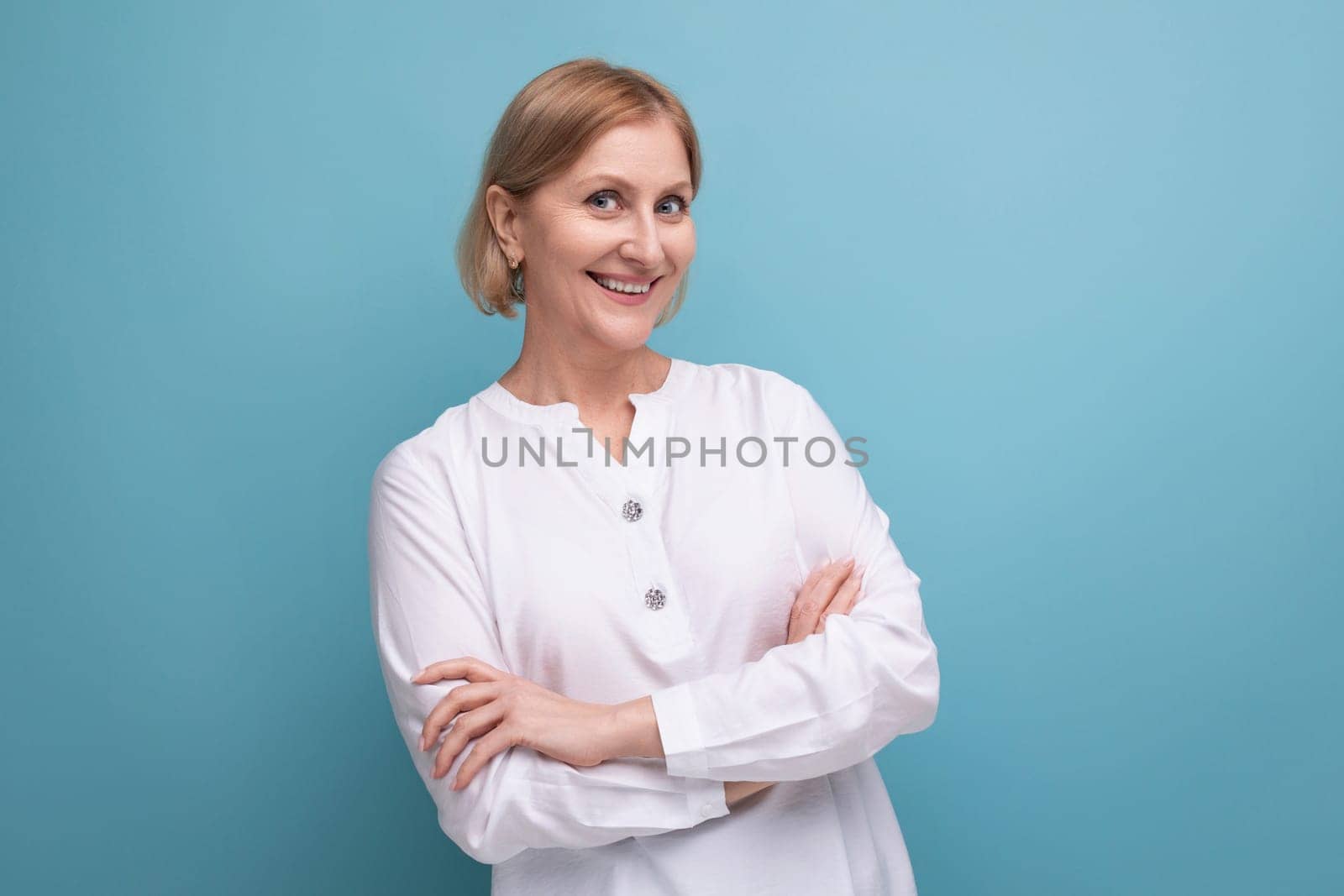 blond bob middle-aged woman in a white blouse in menopause on a studio background.