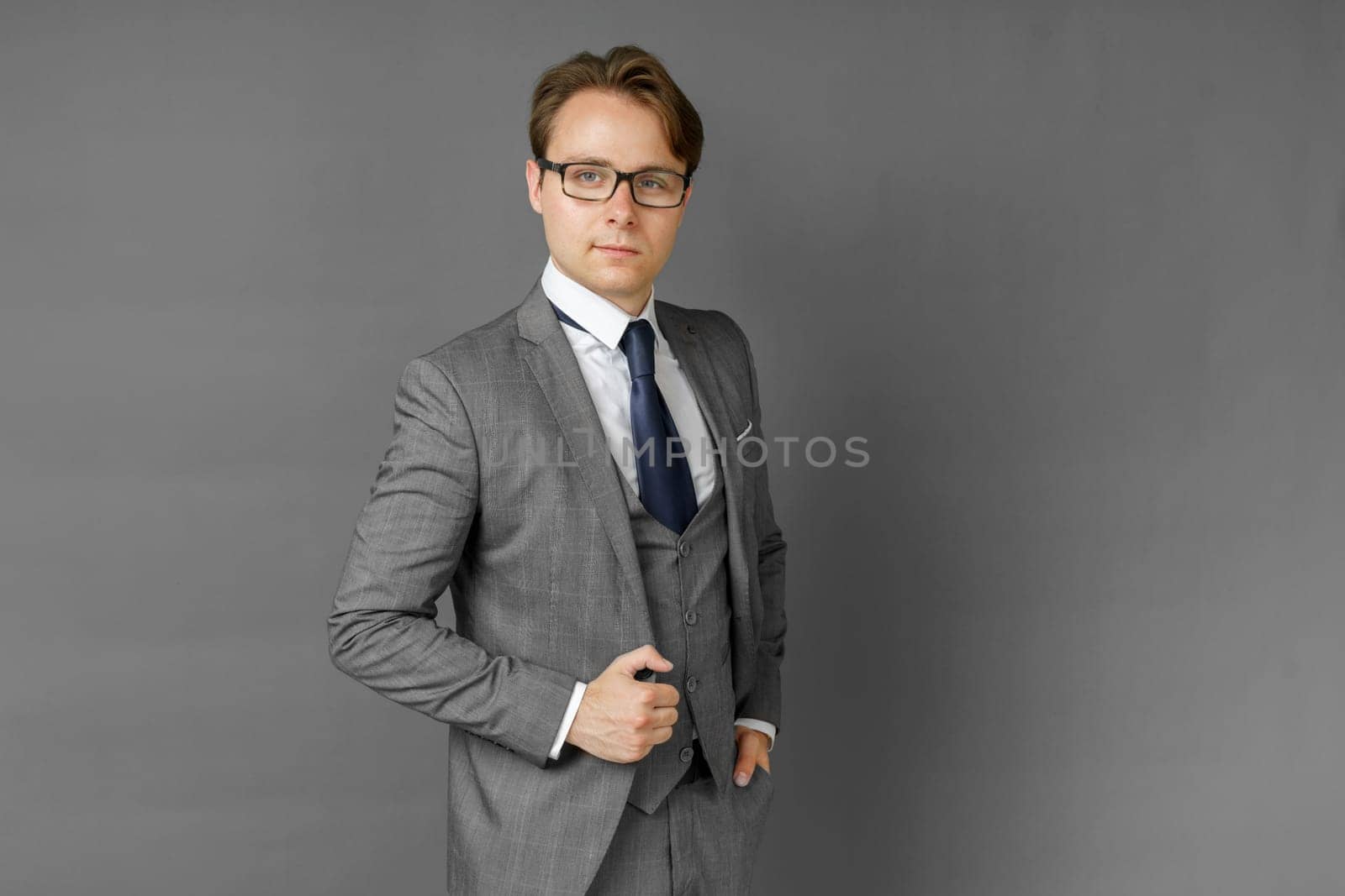 Portrait of a businessman in a suit looking at the camera. Gray background. Business and finance concept