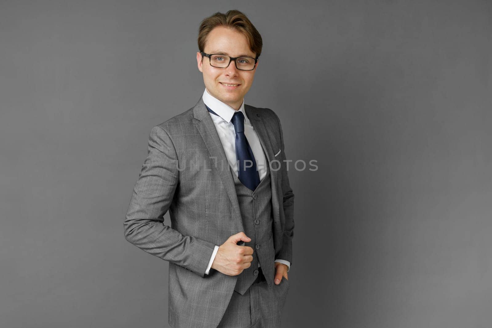 Portrait of a businessman in a suit looking at the camera. Gray background. by Sd28DimoN_1976