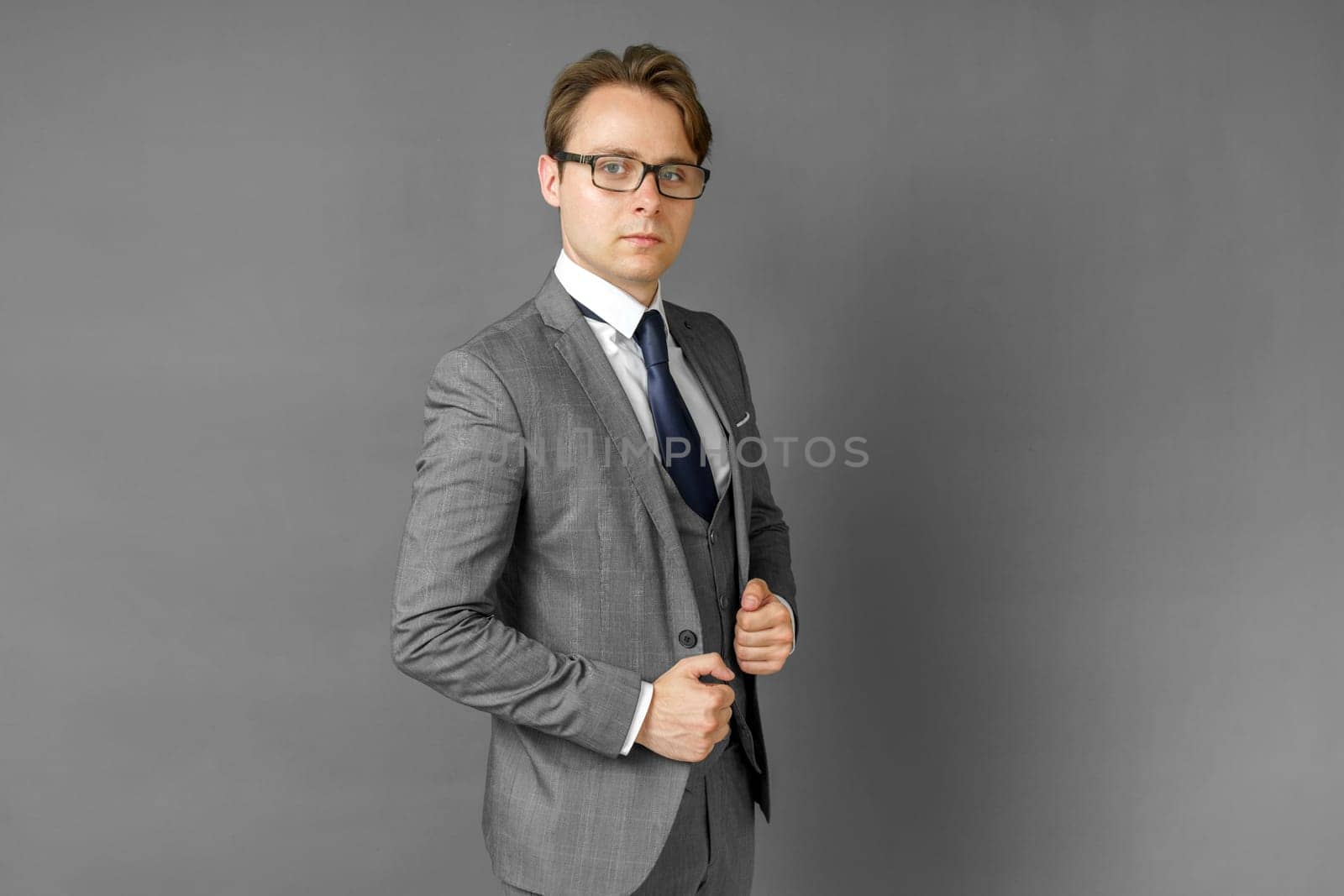 Portrait of a businessman in a suit looking at the camera. Gray background. Business and finance concept