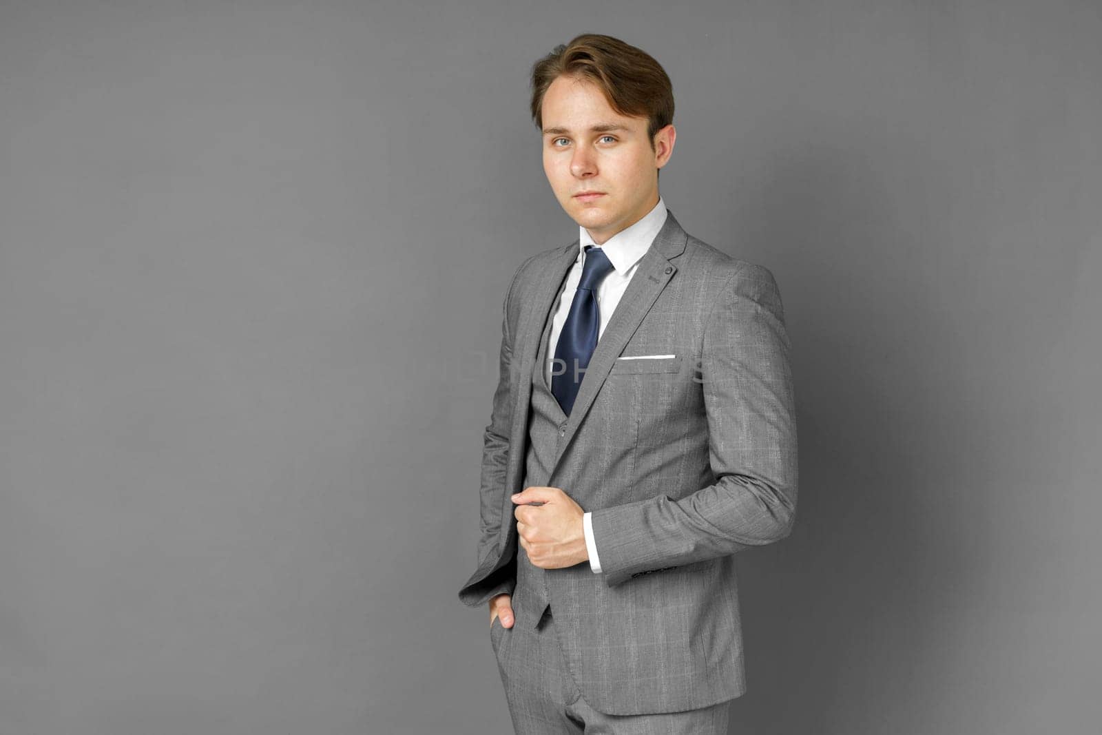 Portrait of a businessman in a suit looking at the camera. Gray background. Business and finance concept