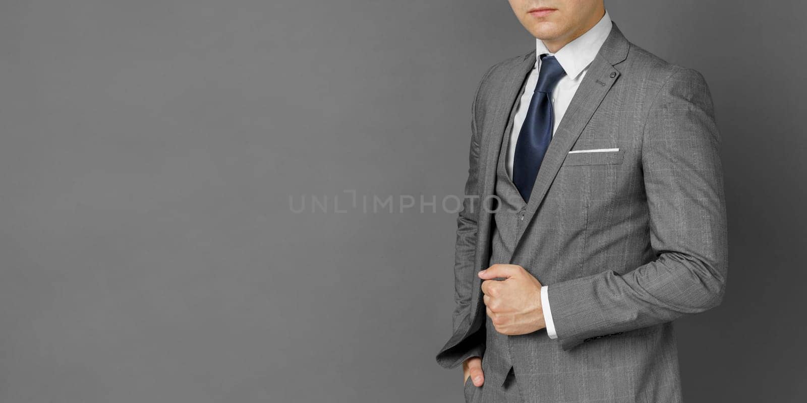 Portrait of a businessman in a suit. No face visible. Gray background. Business and finance concept