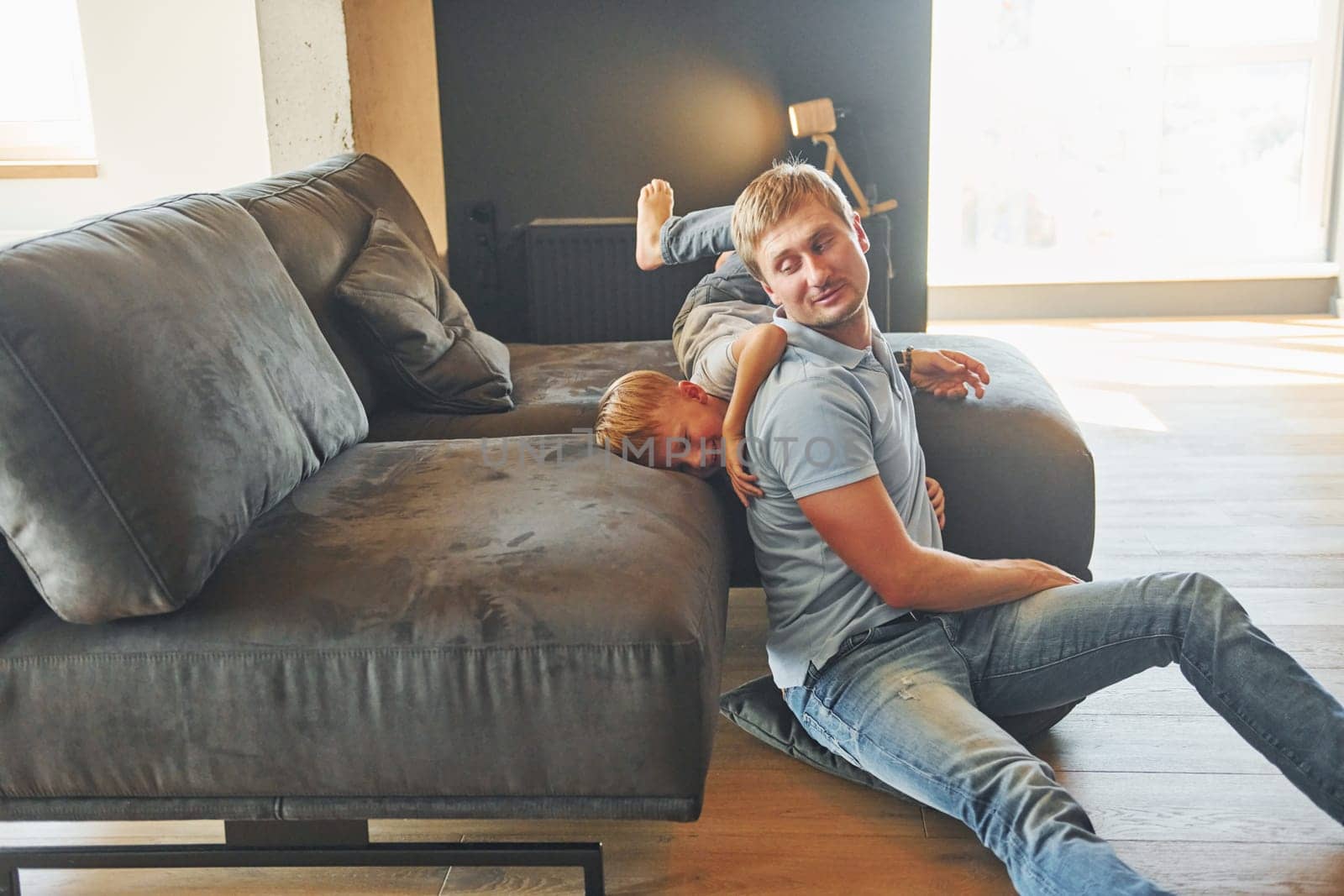 Having fun. Father and son is indoors at home together.