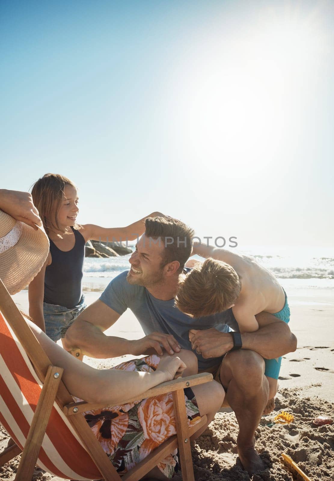 Summer sun means lots of family fun. a happy family of four having fun at the beach. by YuriArcurs