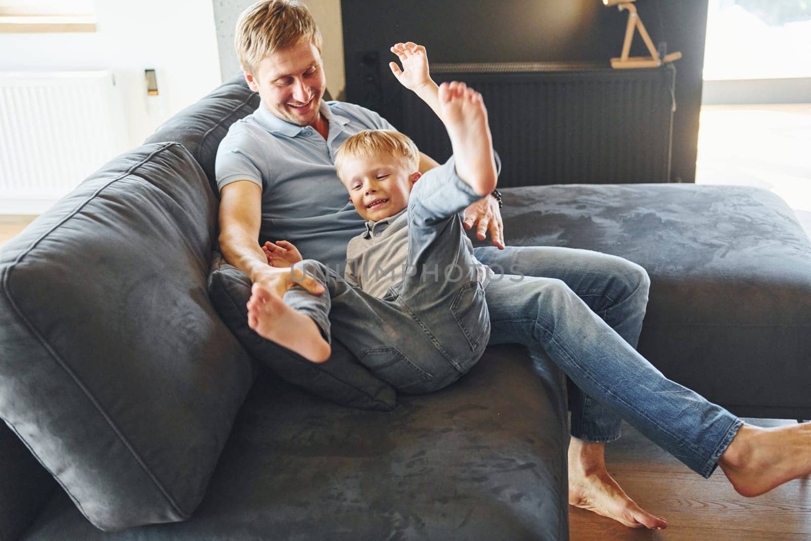 Playing and having fun. Father and son is indoors at home together.