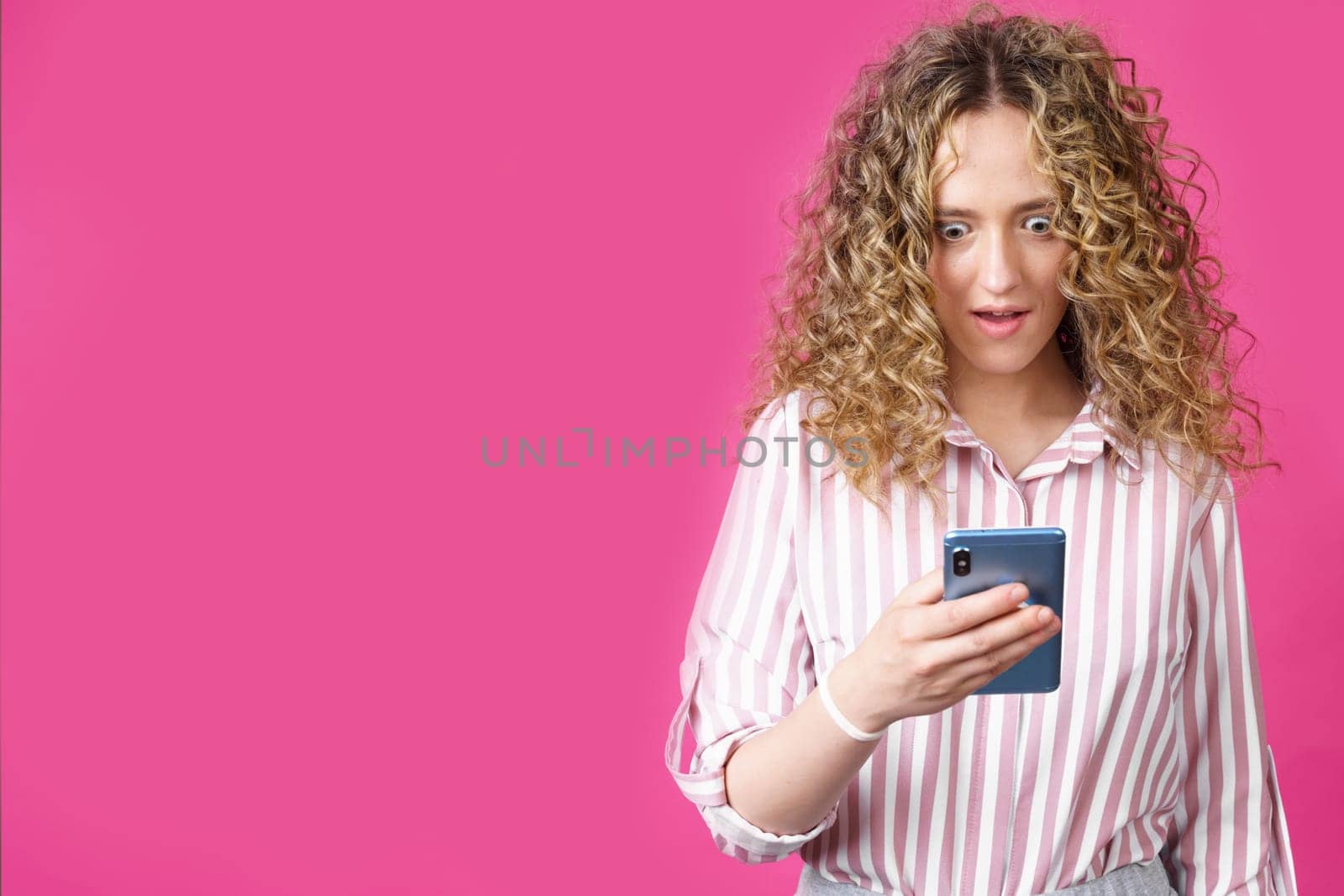A fashionable woman in a striped shirt, holds a mobile phone, gasps in surprise, reads amazing news. by Sd28DimoN_1976