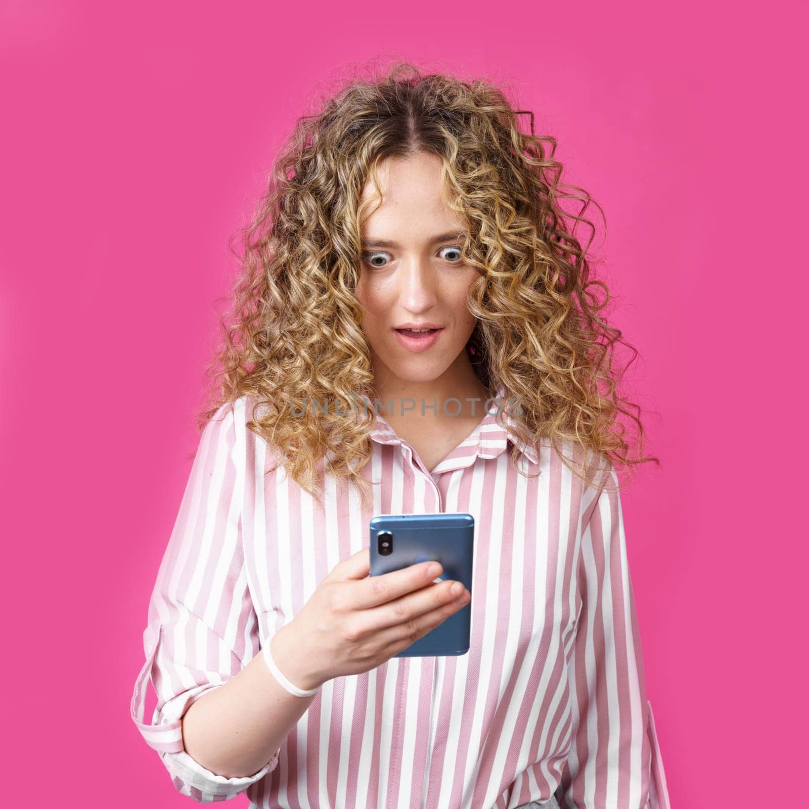 A fashionable woman in a striped shirt, holds a mobile phone, gasps in surprise, reads amazing news. by Sd28DimoN_1976