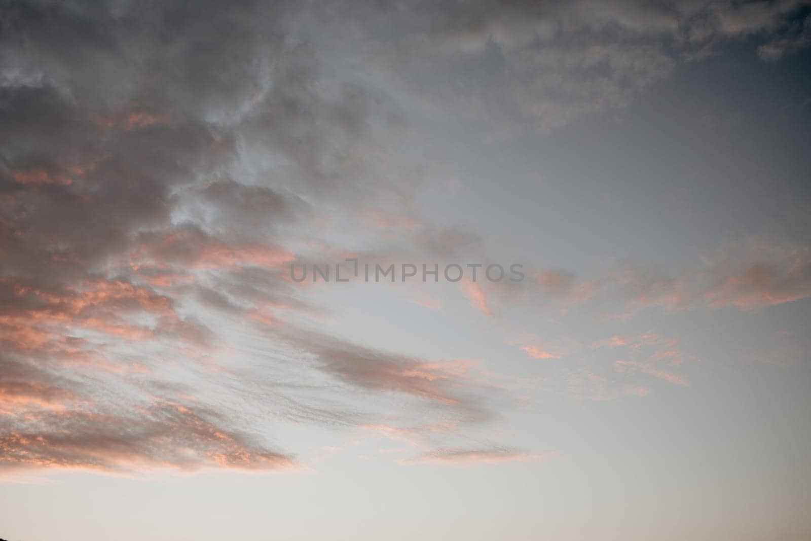 A red burning sunset with the silhouette of a cliff over the sea. Abstract nature summer or spring ocean sea background. Small waves on golden warm water surface with bokeh lights from sun.